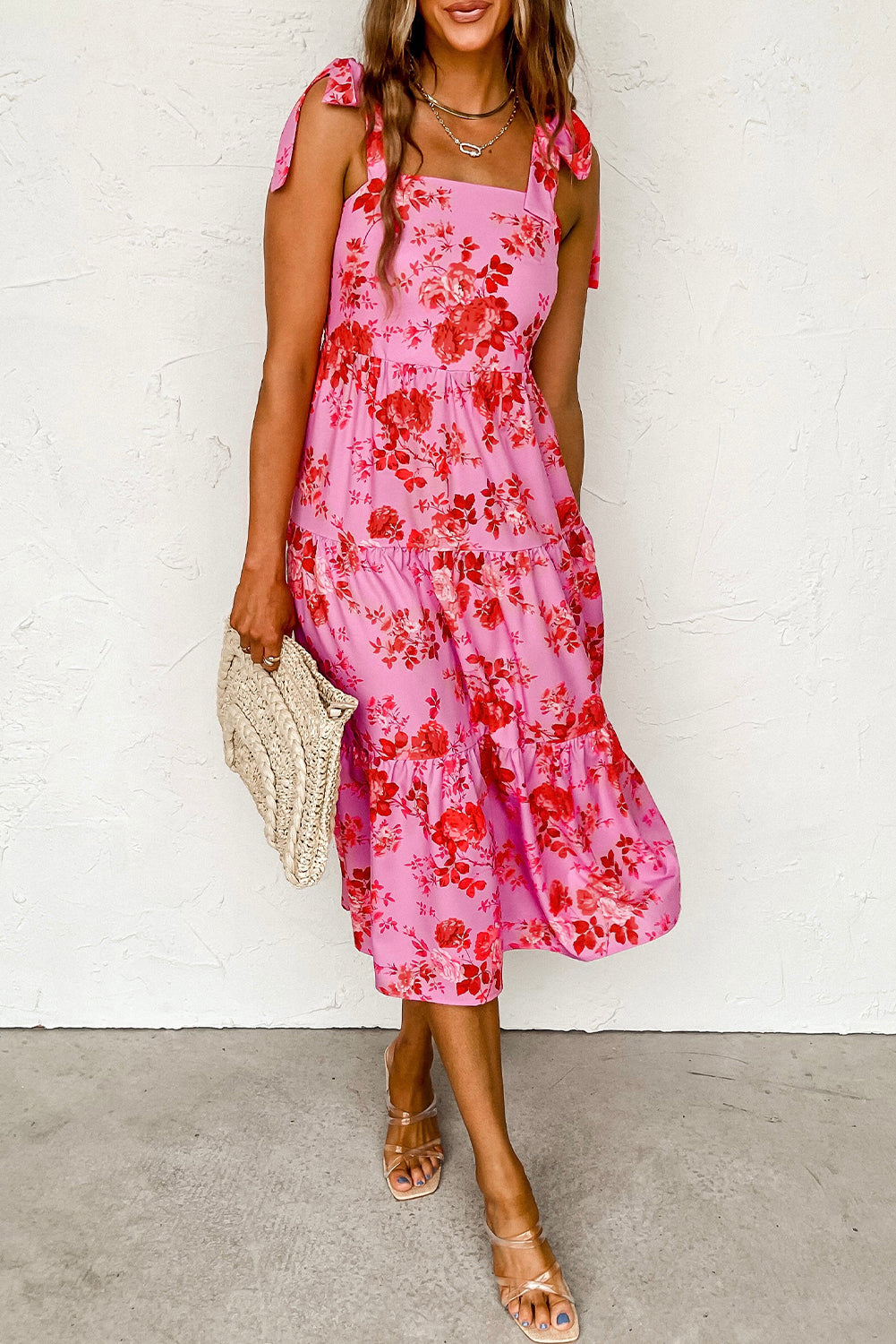 A beautiful blue tiered floral dress with tie shoulder straps, perfect for summer occasions.