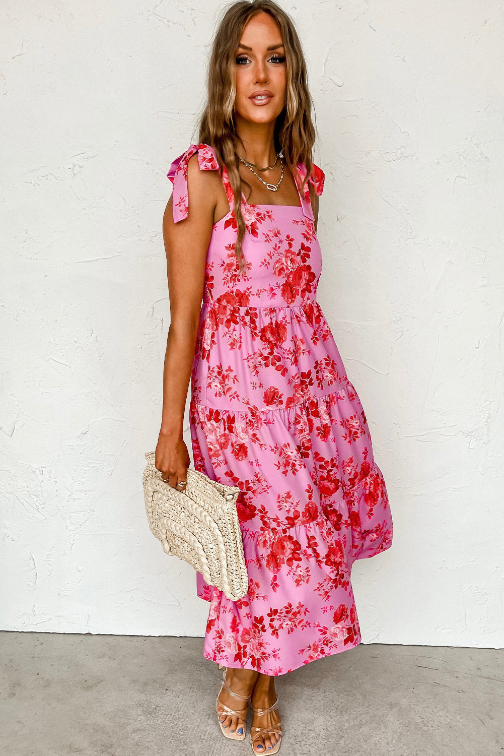 A beautiful blue tiered floral dress with tie shoulder straps, perfect for summer occasions.