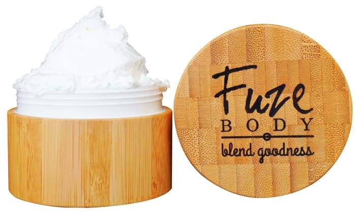 A jar of Body Butter - Breathe Clear in a beautifully engraved bamboo container, showcasing its light and fluffy texture.