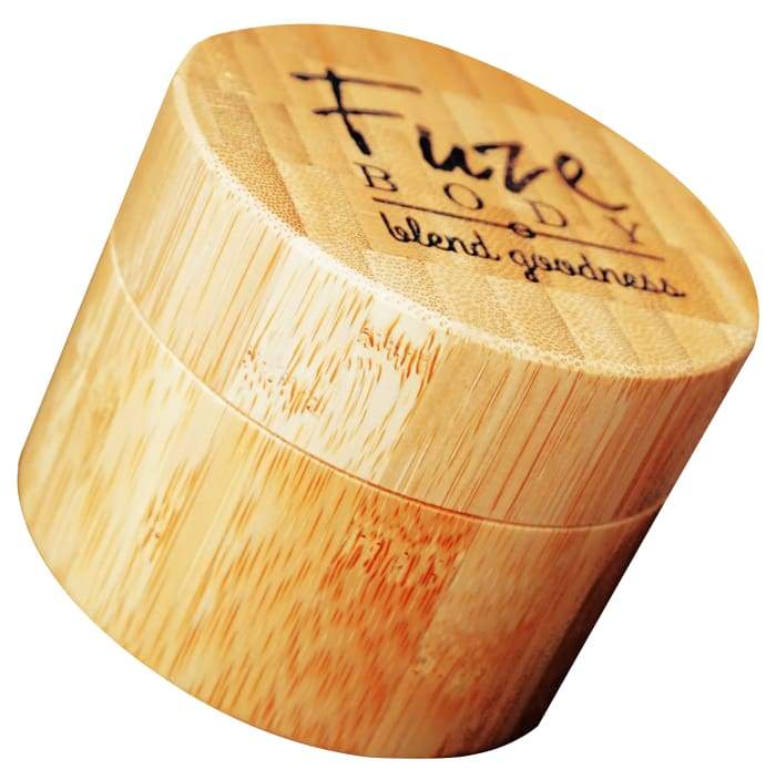 A jar of Body Butter - Focus in a beautifully engraved bamboo container, showcasing its light and fluffy texture.