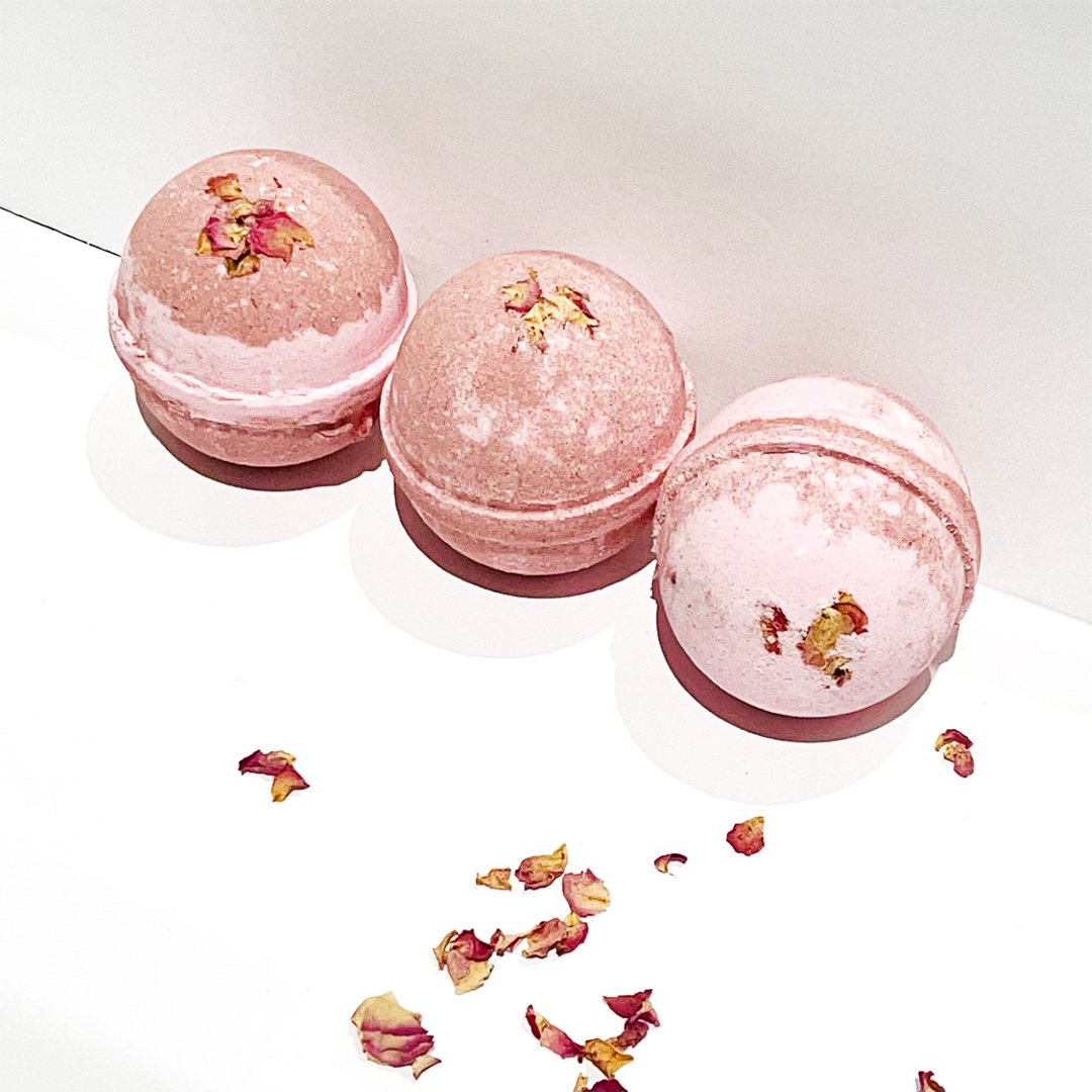 Botanic Garden Wild Rose Bath Bomb in pink water, showcasing its vibrant color and floral design.