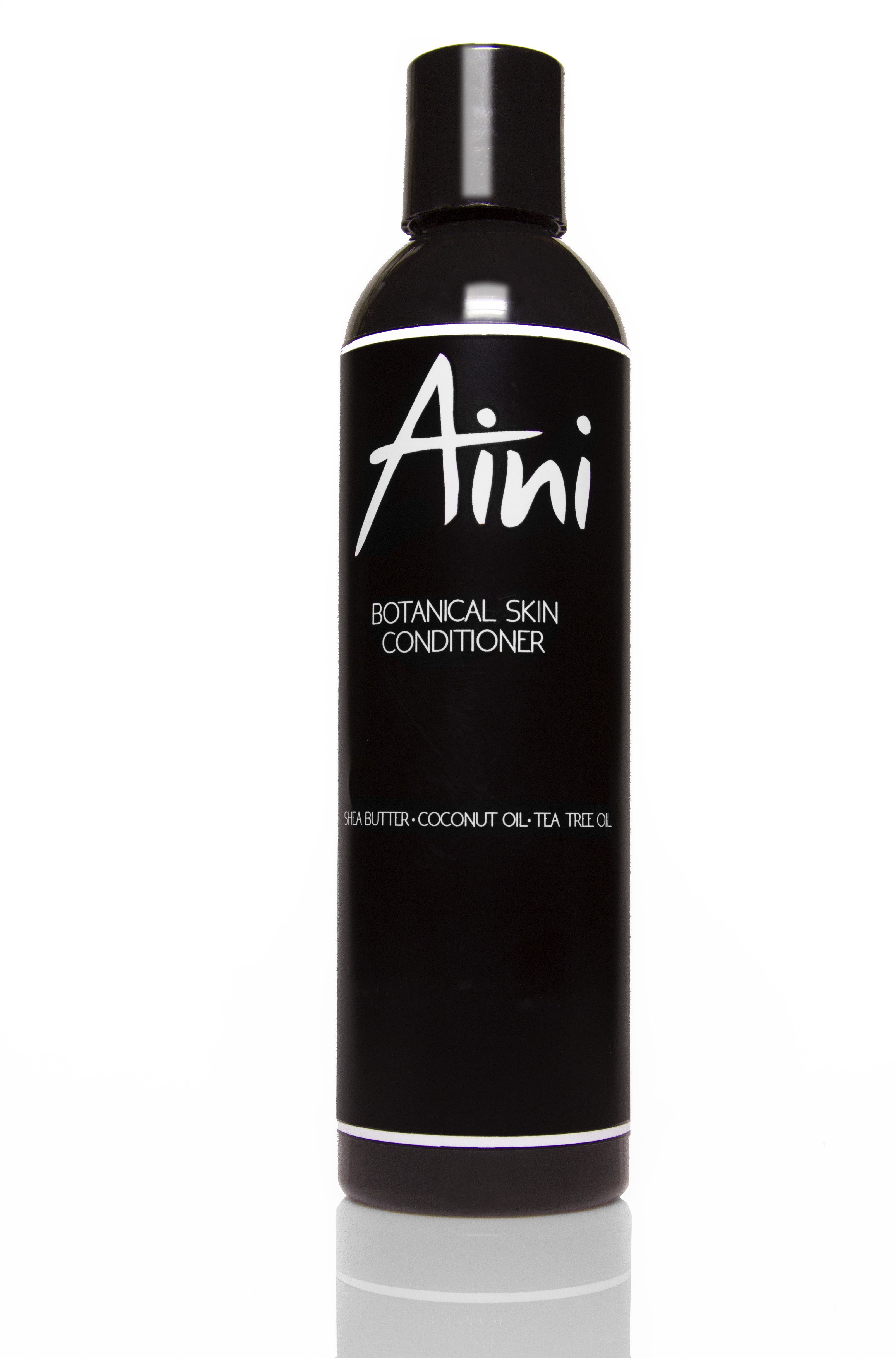 A bottle of Botanical Skin Conditioner featuring a lightweight formula with tea tree oil and shea butter, surrounded by natural ingredients like coconut oil and vanilla beans.