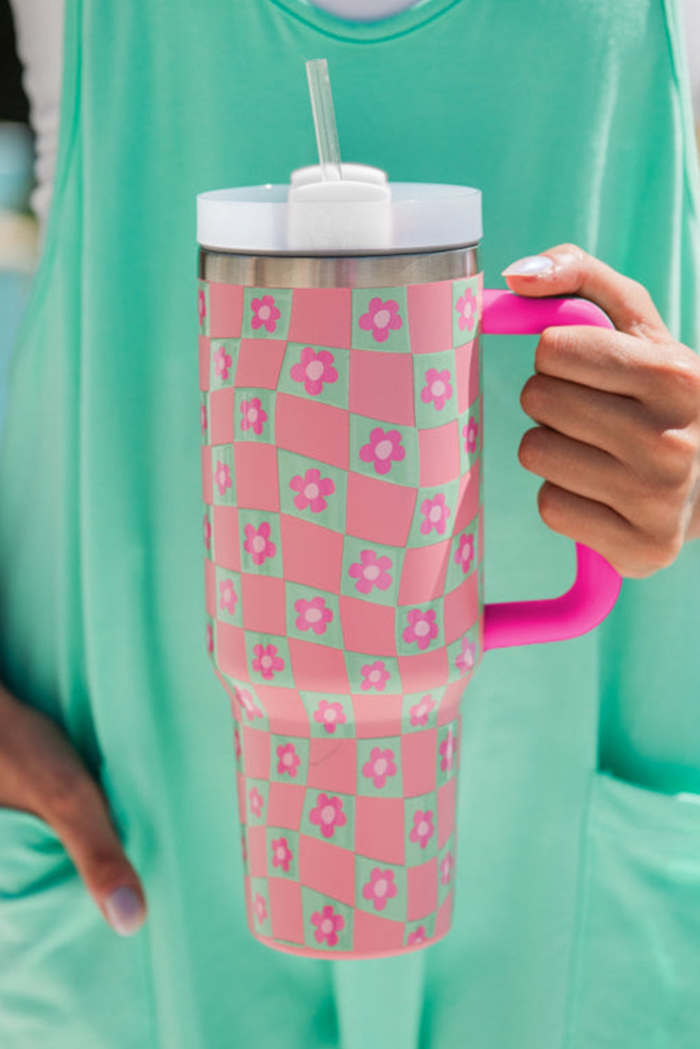 Bright pink cup with a checkered pattern and floral design, featuring a reusable straw, perfect for drinks.