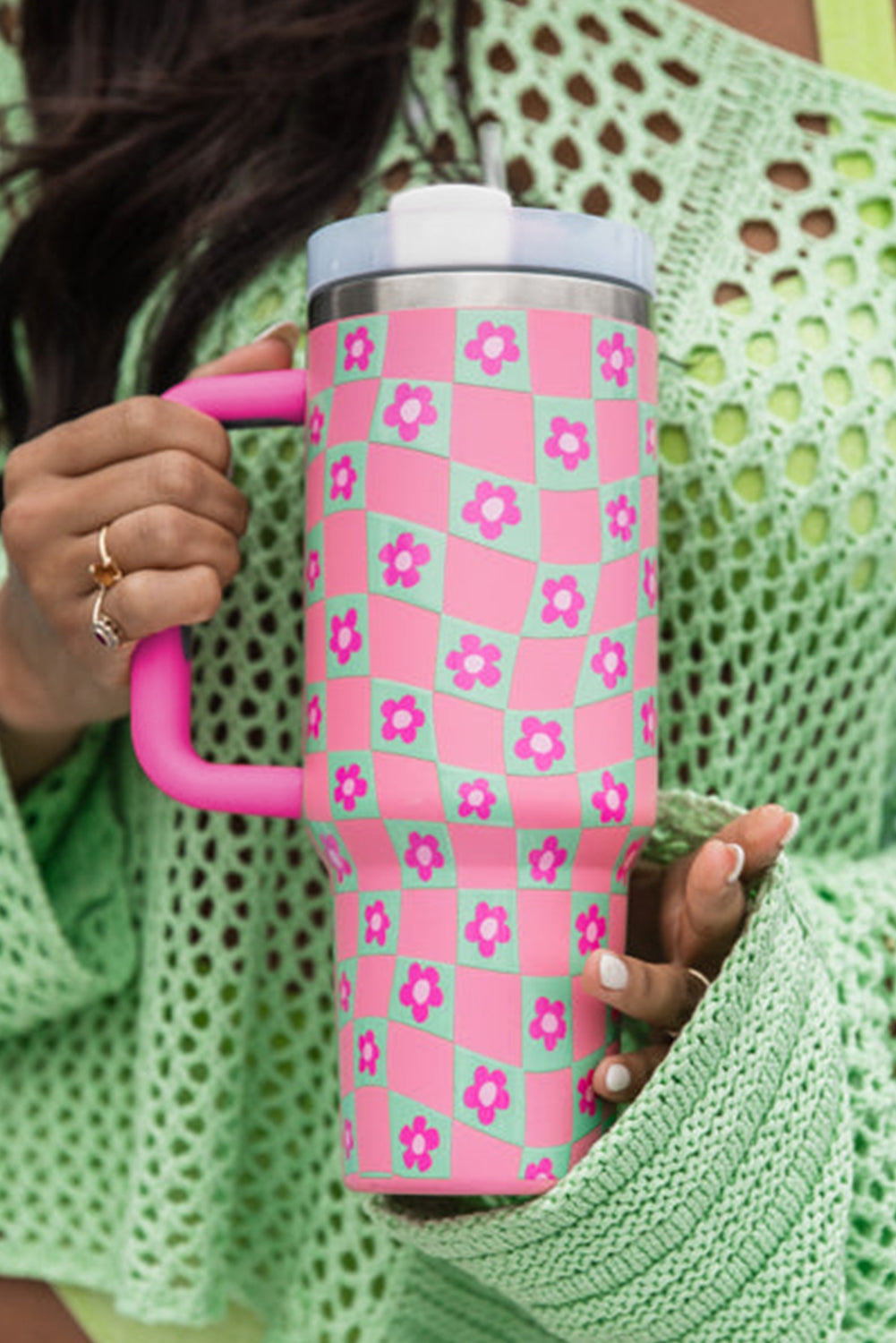 Bright pink cup with a checkered pattern and floral design, featuring a reusable straw, perfect for drinks.