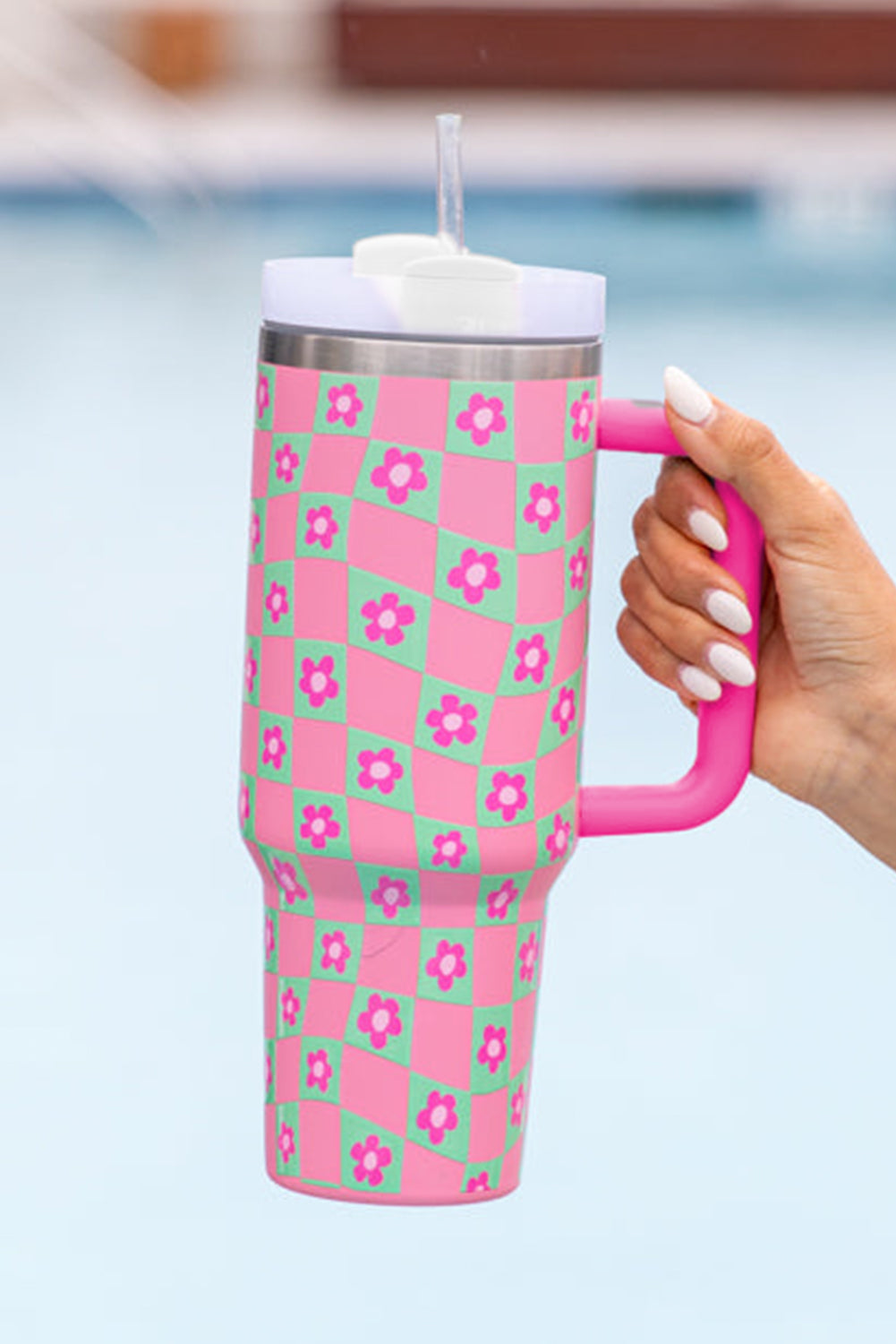 Bright pink cup with a checkered pattern and floral design, featuring a reusable straw, perfect for drinks.