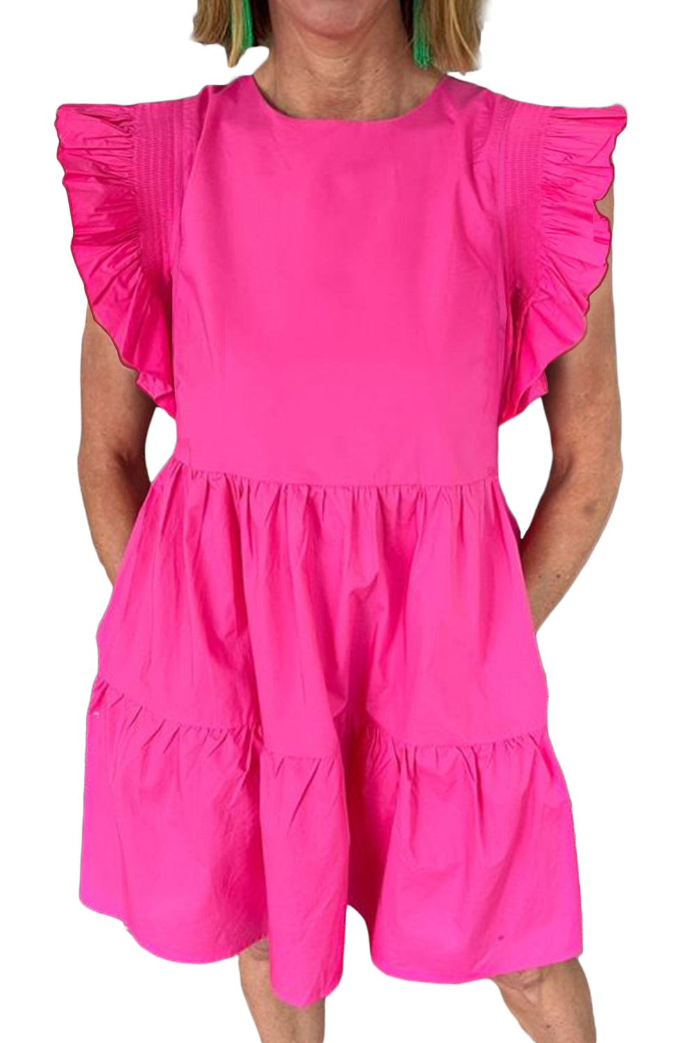 Bright pink ruffled babydoll mini dress displayed on a mannequin, showcasing its playful design and vibrant color.