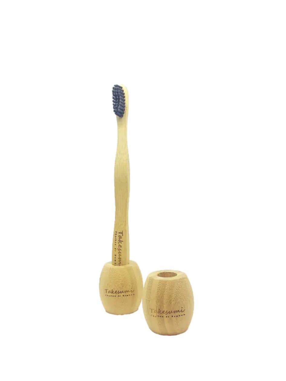 Brosse à dents en bambou infusée au charbon de bambou avec tête en nylon, accompagnée d'un pochon en coton naturel.