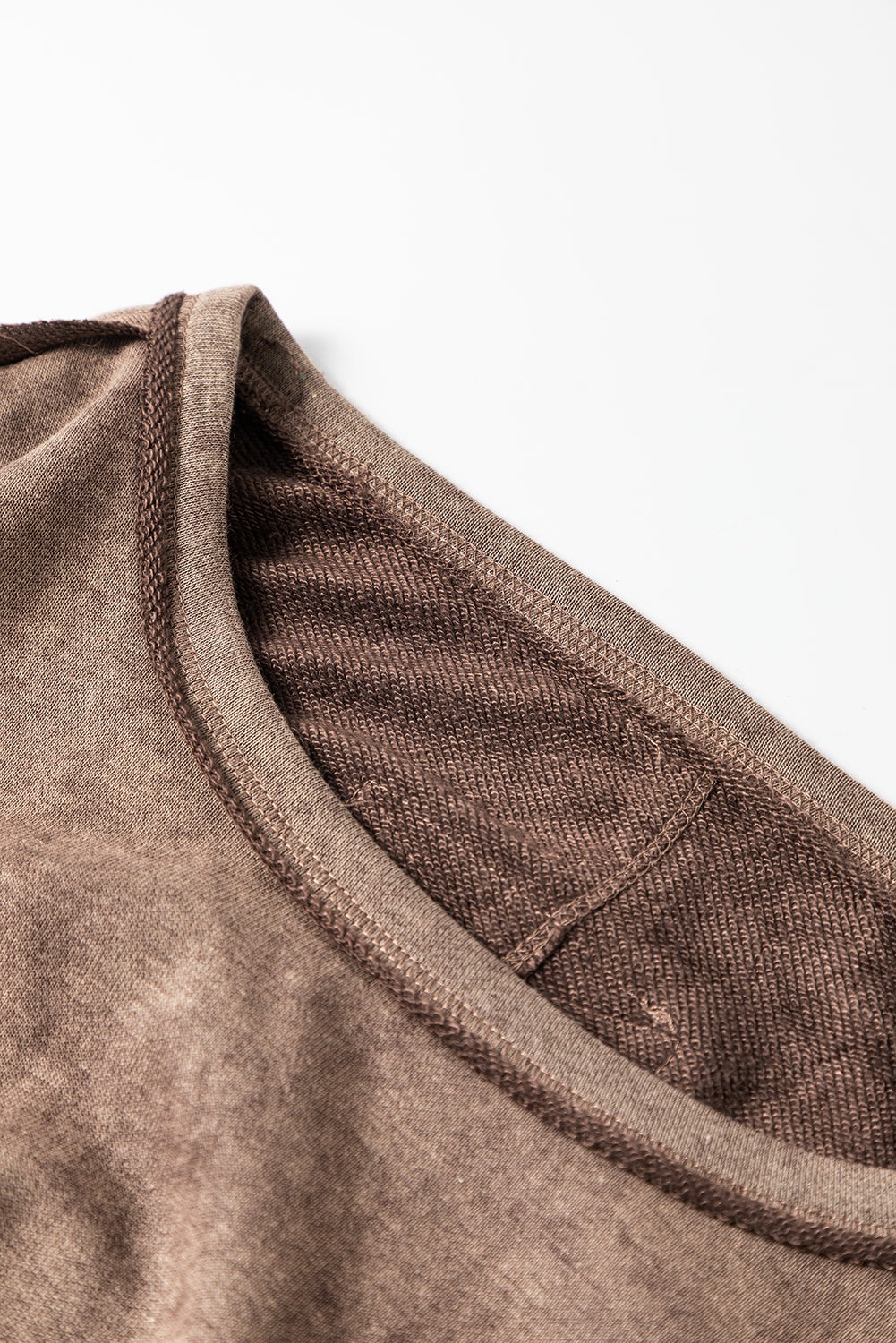 Brown sweatshirt with exposed seams and thumbholes, featuring a drop shoulder design for a relaxed fit.