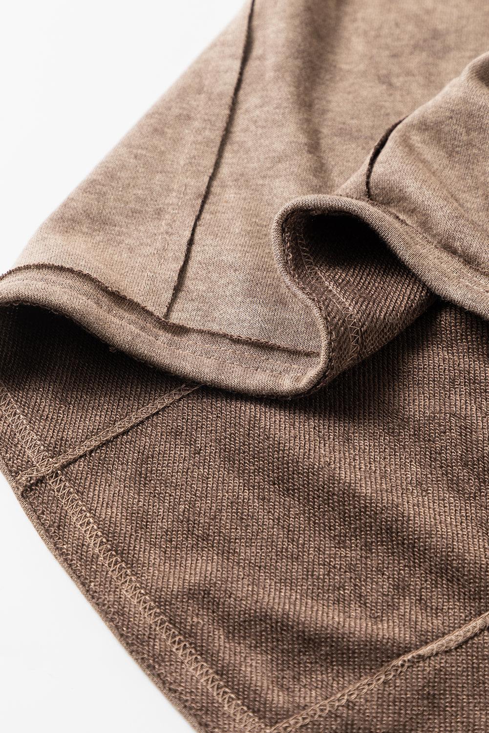 Brown sweatshirt with exposed seams and thumbholes, featuring a drop shoulder design for a relaxed fit.