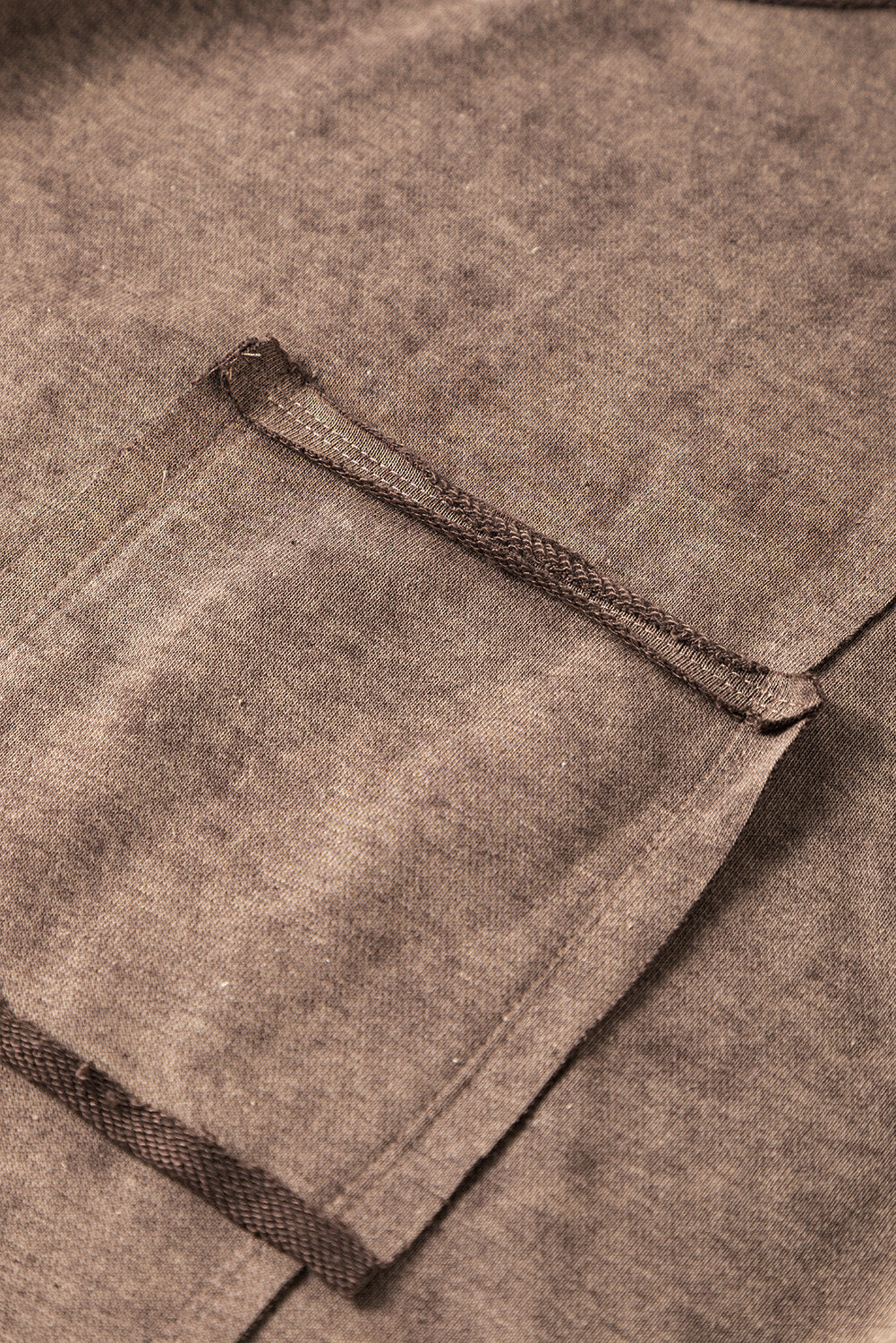 Brown sweatshirt with exposed seams and thumbholes, featuring a drop shoulder design for a relaxed fit.