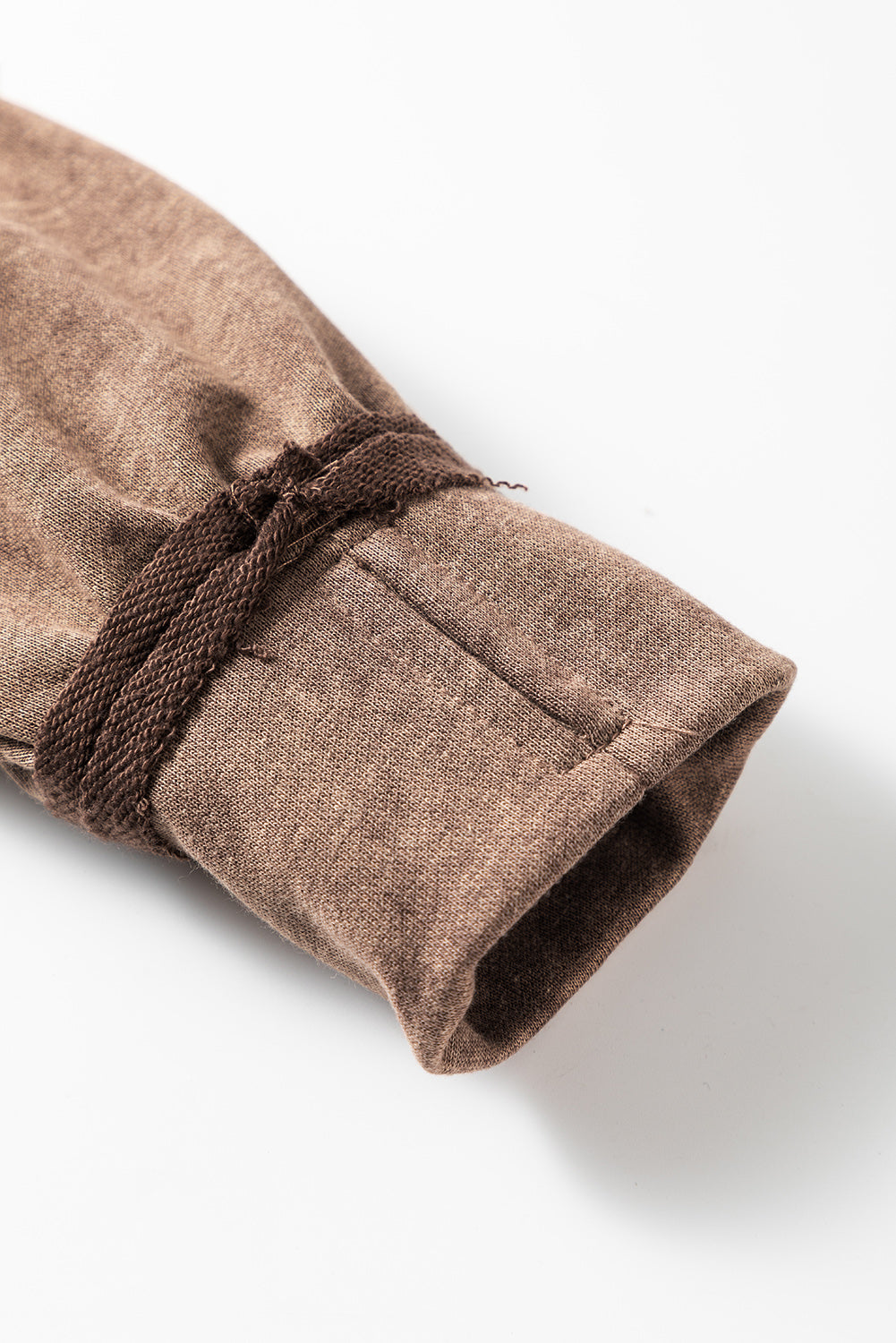 Brown sweatshirt with exposed seams and thumbholes, featuring a drop shoulder design for a relaxed fit.