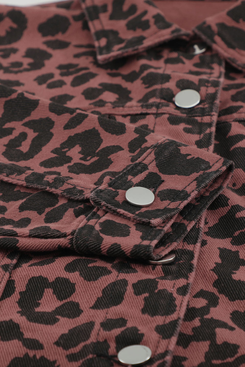 Brown leopard print cropped jacket with raw hem and button closure, featuring flap pockets and a stylish turn-down collar.