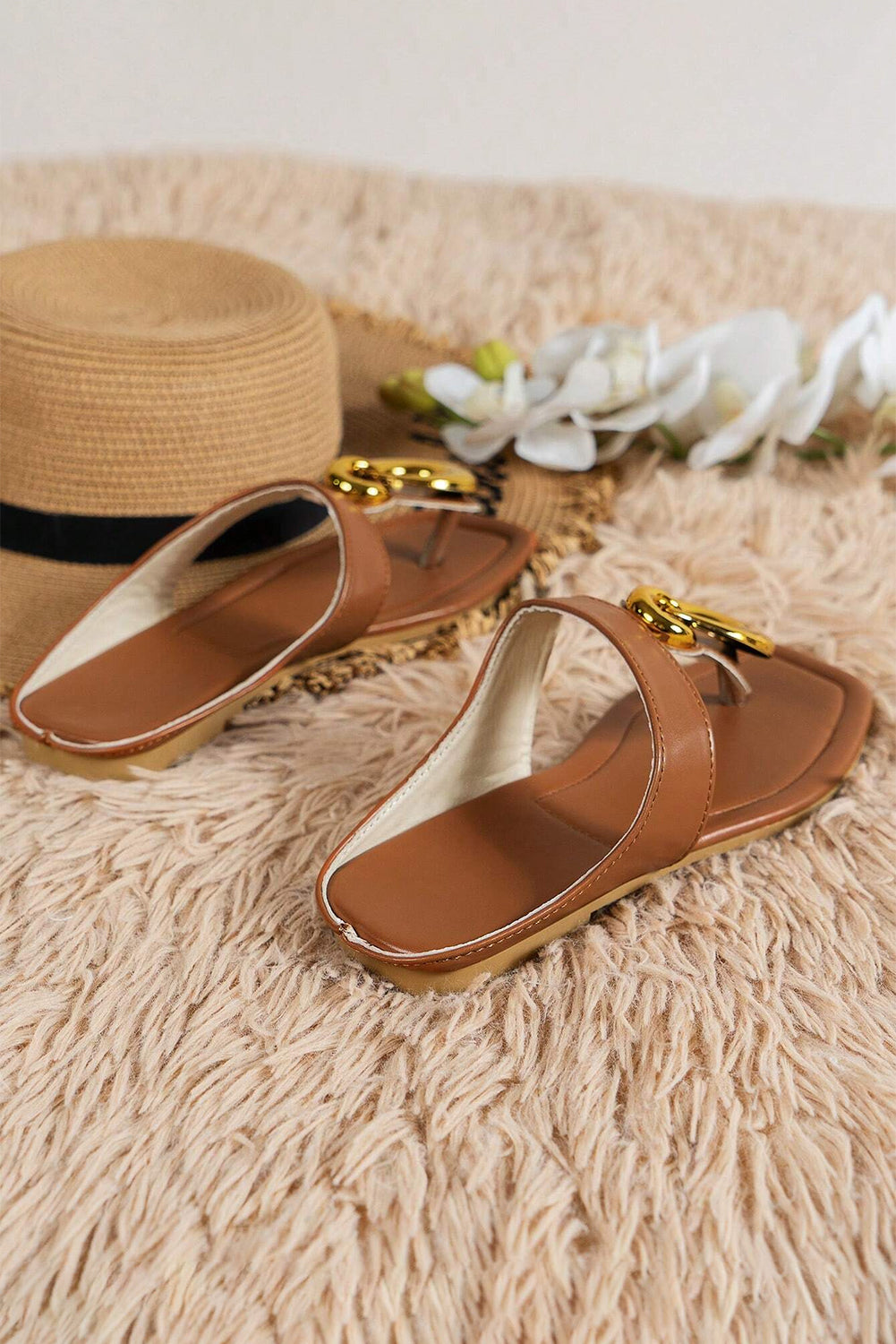 Brown flat slippers featuring decorative metal rings and a square toe design, perfect for stylish comfort.