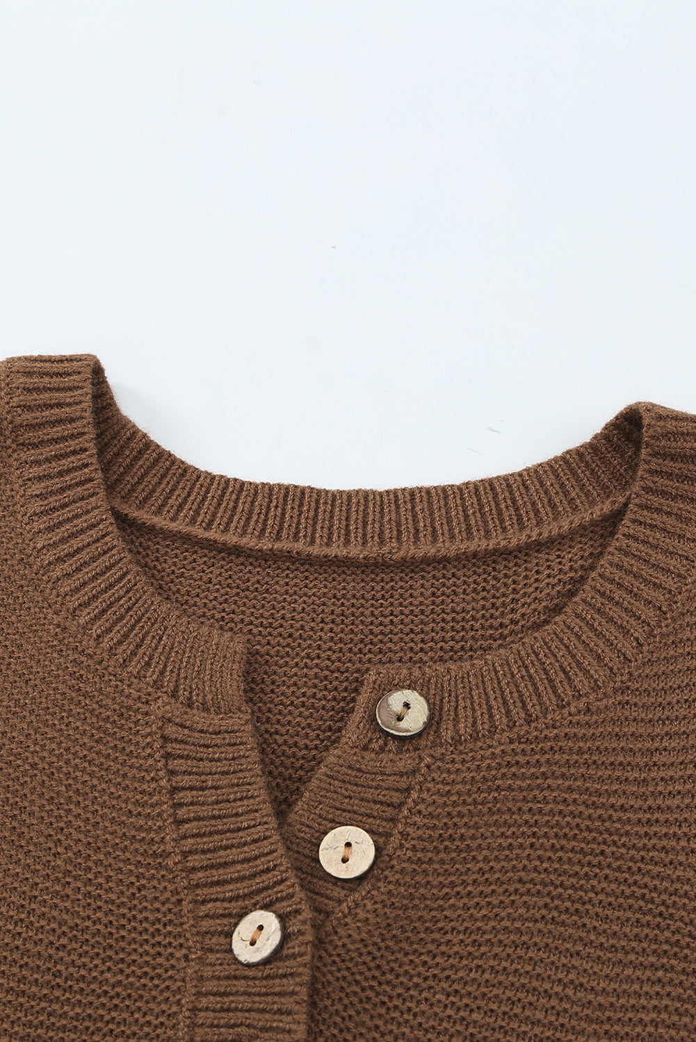 A stylish brown knitted long sleeve sweater featuring color splicing and buttoned design, perfect for casual outfits.