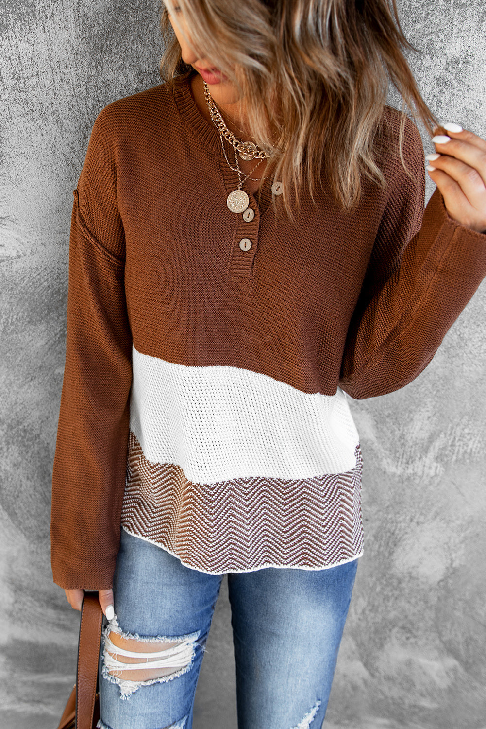 A stylish brown knitted long sleeve sweater featuring color splicing and buttoned design, perfect for casual outfits.