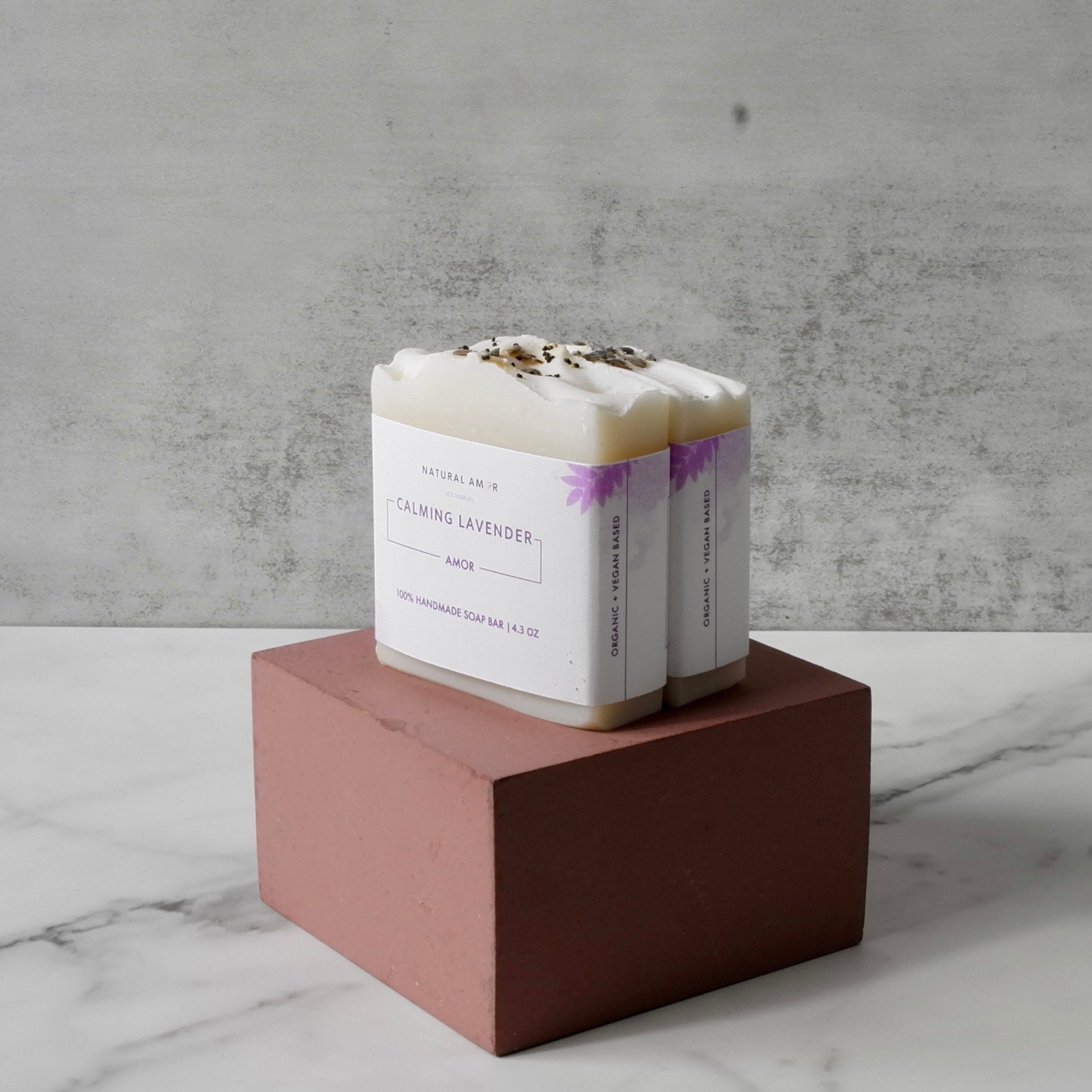 Calming Lavender Soap Bar with natural ingredients, featuring a soothing lavender color and dried lavender pieces.