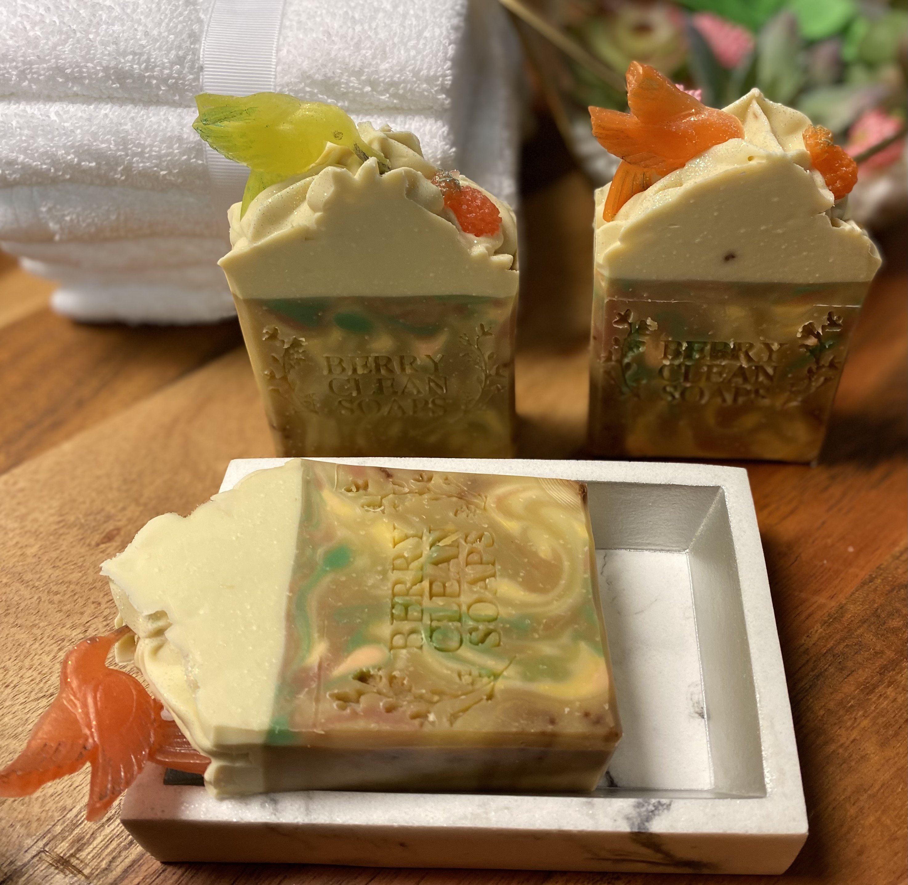 A vibrant bar of Caribbean Soap shaped like tropical fruits, featuring coconut and pineapple scents, with a creamy texture and colorful mica coloring.