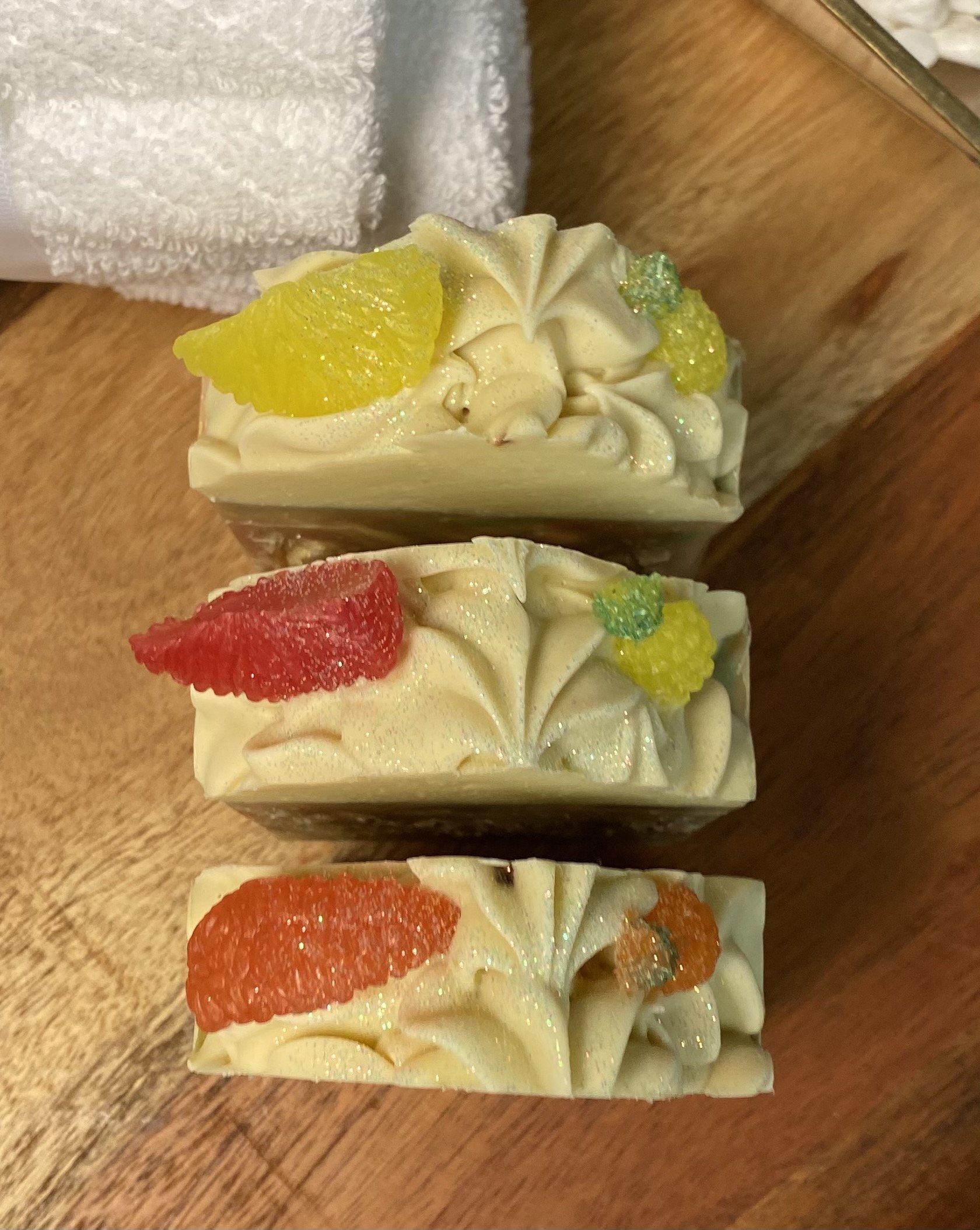 A vibrant bar of Caribbean Soap shaped like tropical fruits, featuring coconut and pineapple scents, with a creamy texture and colorful mica coloring.