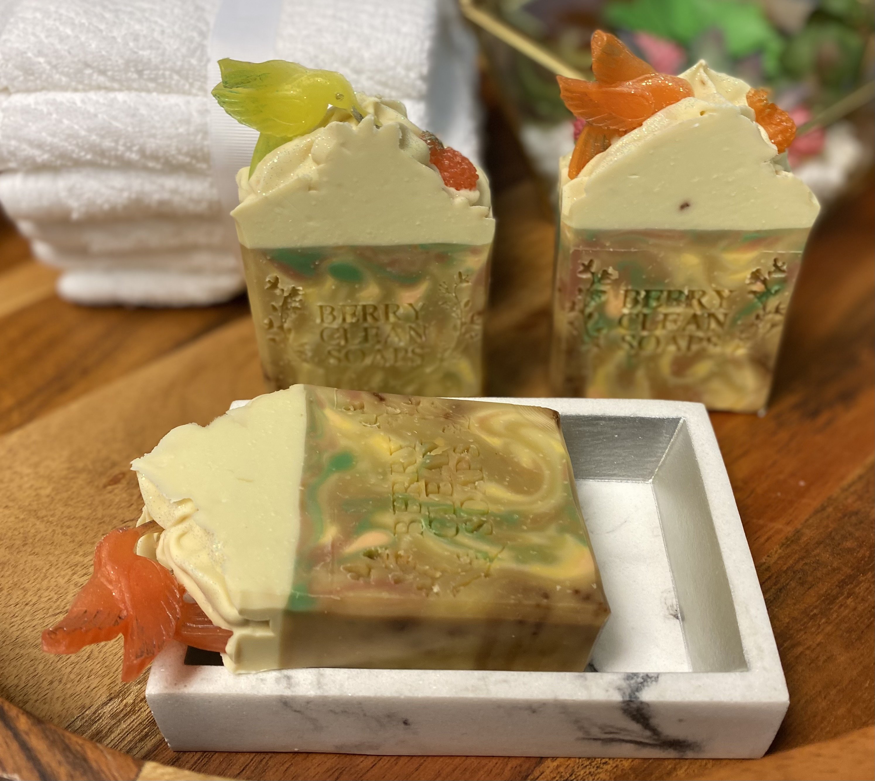 A vibrant bar of Caribbean Soap shaped like tropical fruits, featuring coconut and pineapple scents, with a creamy texture and colorful mica coloring.