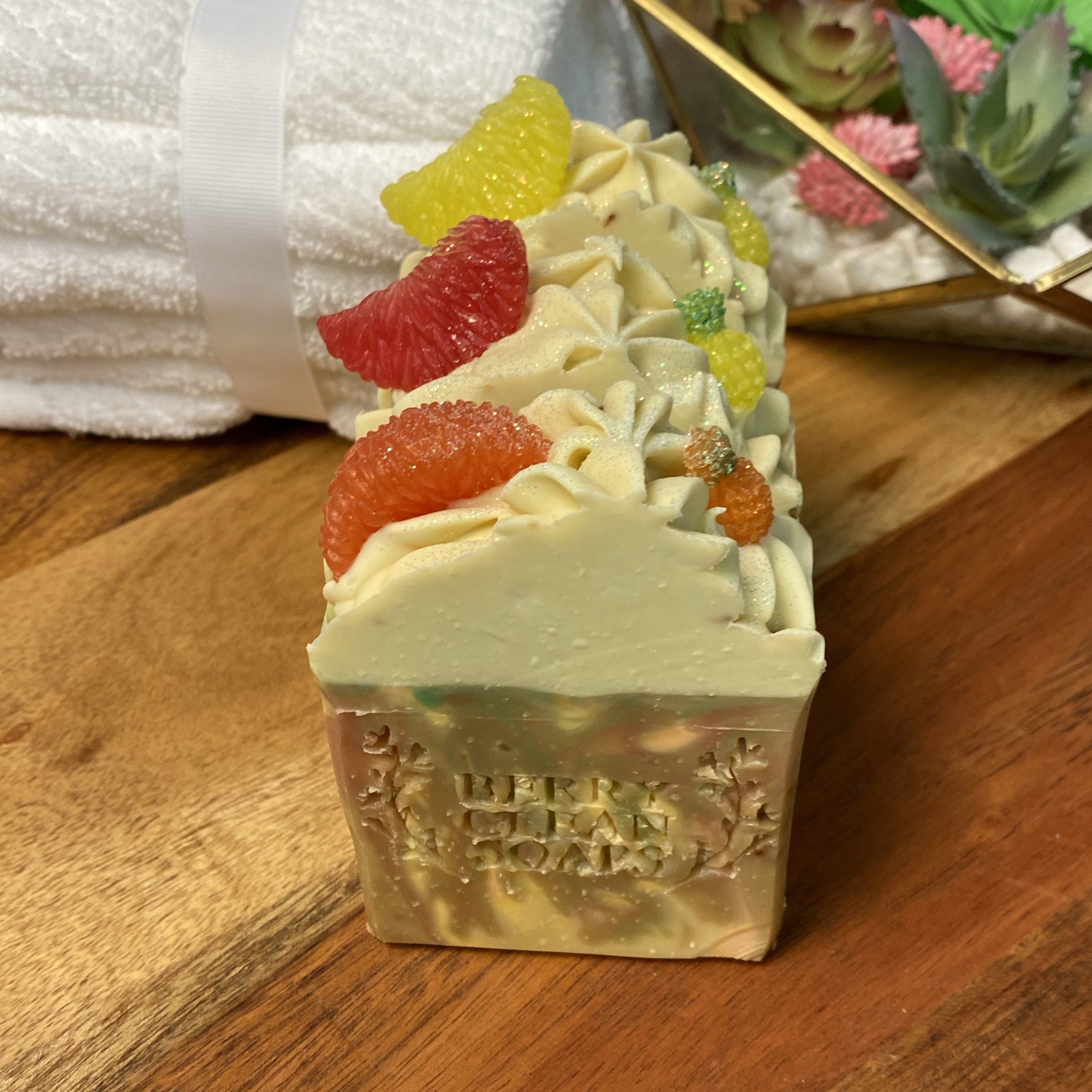 A vibrant bar of Caribbean Soap shaped like tropical fruits, featuring coconut and pineapple scents, with a creamy texture and colorful mica coloring.