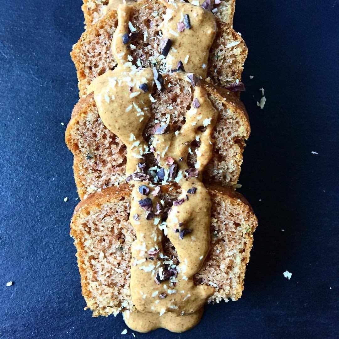 A jar of Cinnamon Snickerdoodle Almond + Cashew Nut Butter with a creamy texture and a sprinkle of cinnamon on top, showcasing its delicious flavor.