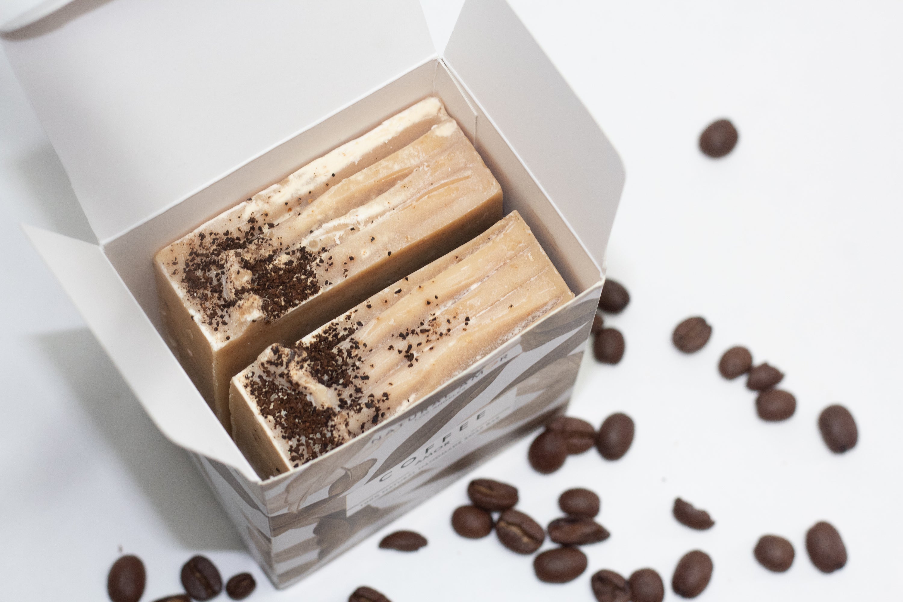 Two bars of Coffee Soap in a stylish box, showcasing natural ingredients and exfoliating walnut shells.