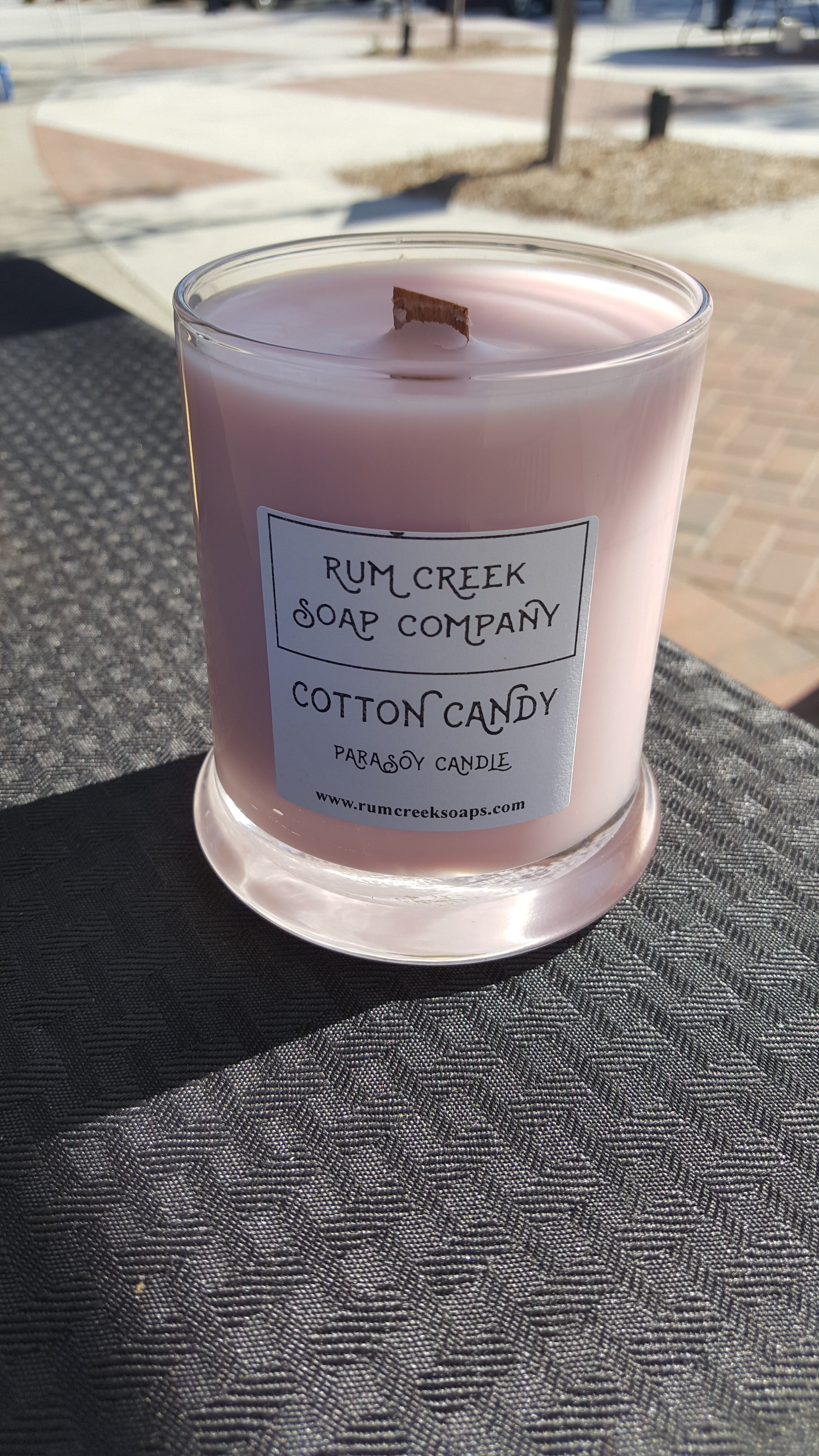 A beautifully crafted Cotton Candy candle with vibrant colors resembling raspberry, strawberry, and vanilla scents, set against a soft background.