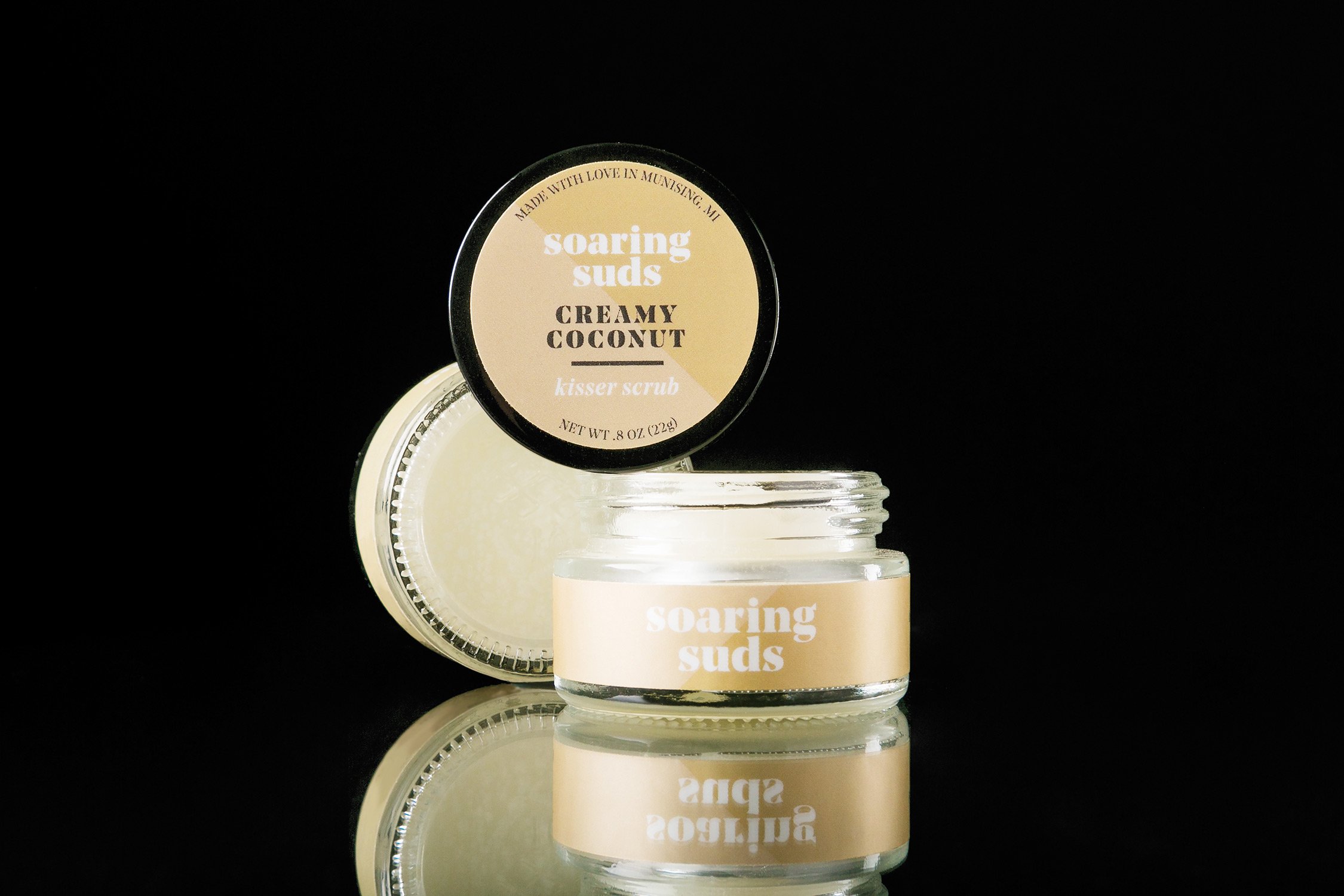 A jar of Creamy Coconut Kisser Scrub with a creamy texture, showcasing its natural ingredients and coconut flavor.