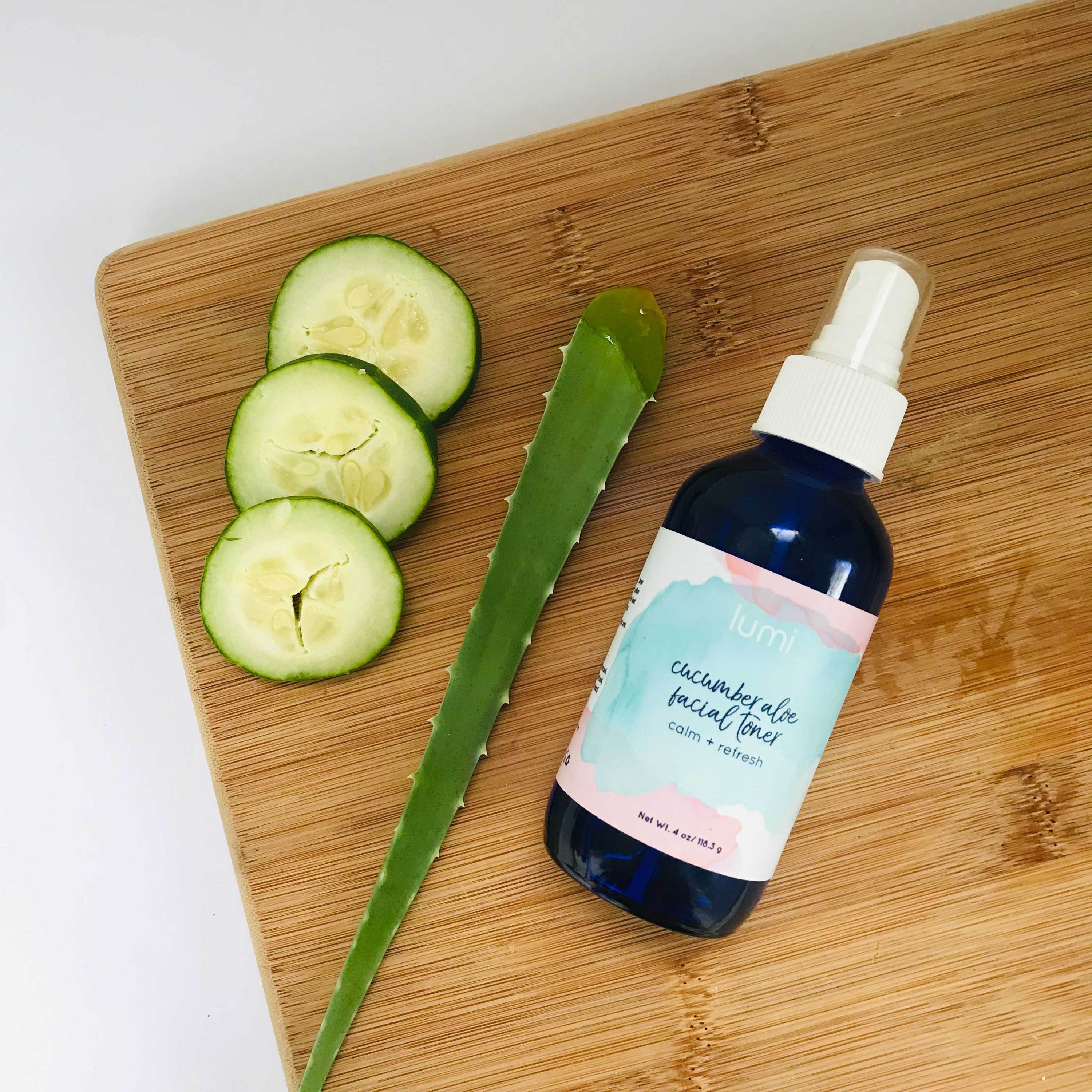 A bottle of Cucumber Aloe Facial Toner with a refreshing green liquid, surrounded by cucumber slices and aloe vera leaves.