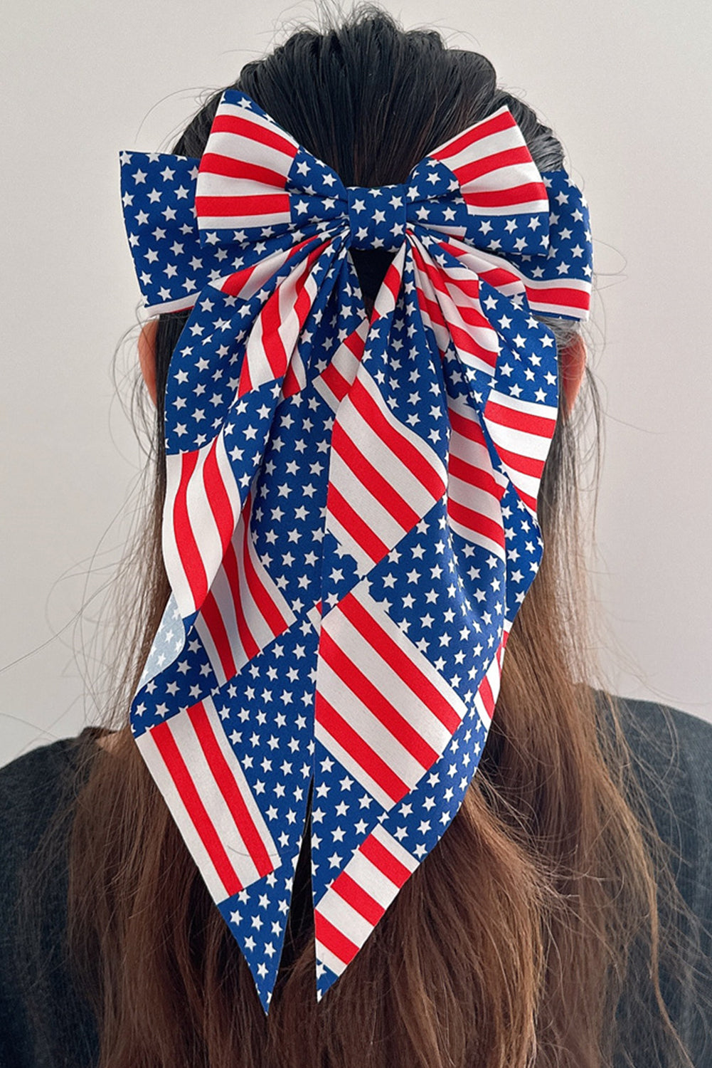 Dark blue hair clip featuring a large bow design with an American flag pattern, perfect for patriotic occasions.