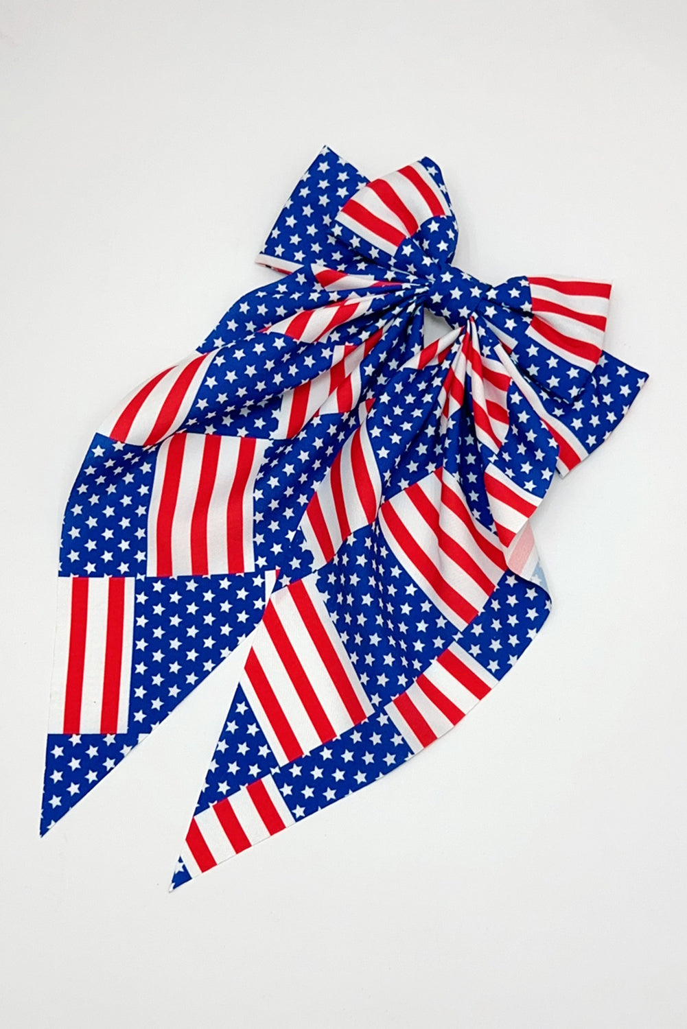 Dark blue hair clip featuring a large bow design with an American flag pattern, perfect for patriotic occasions.