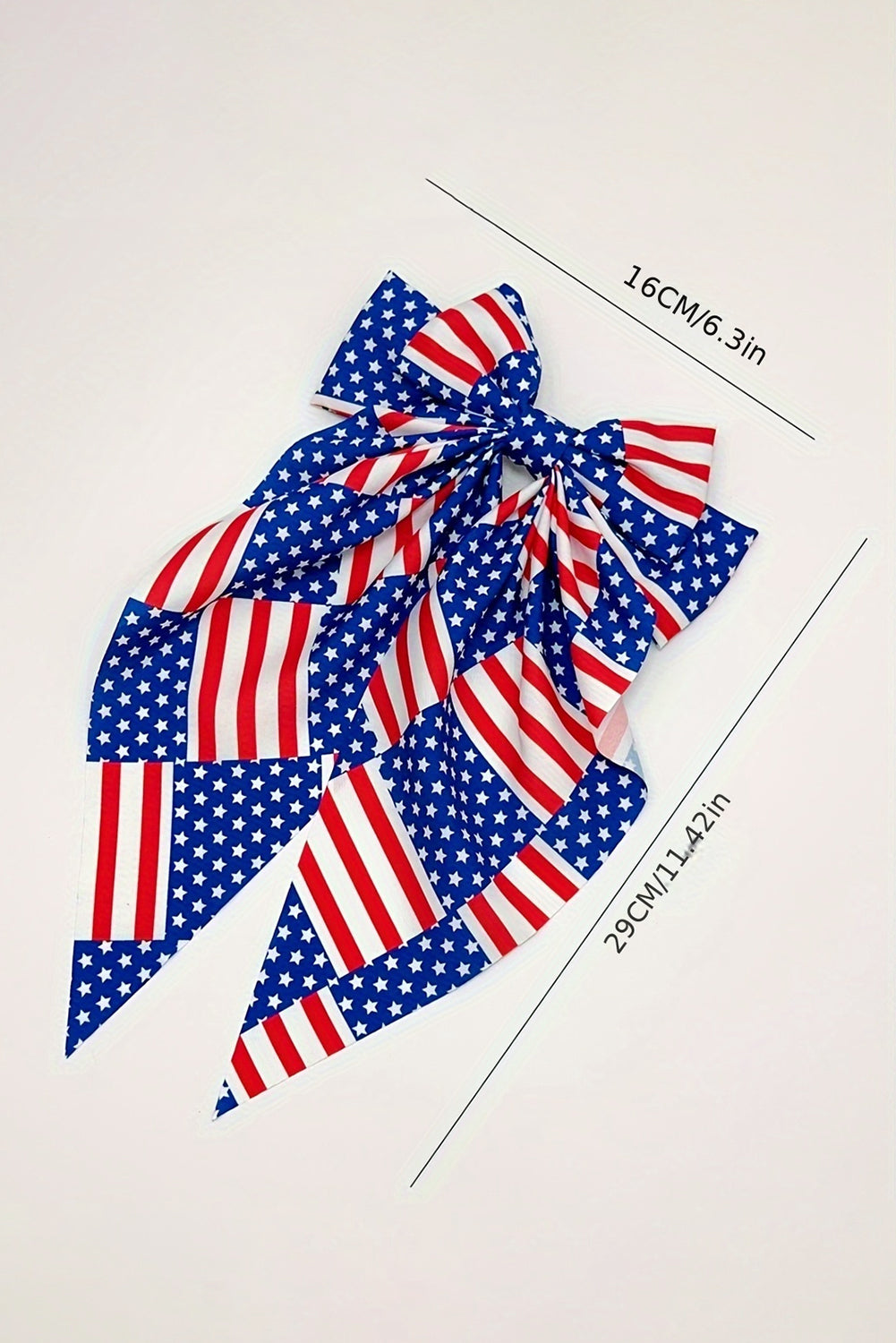 Dark blue hair clip featuring a large bow design with an American flag pattern, perfect for patriotic occasions.