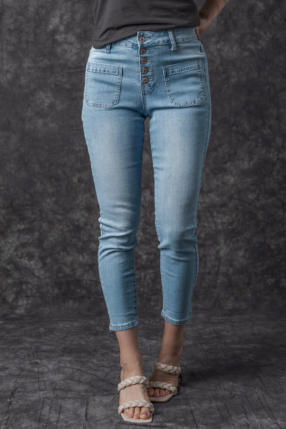 Dark blue skinny jeans featuring a button fly closure and pockets, designed for a stylish and comfortable fit.