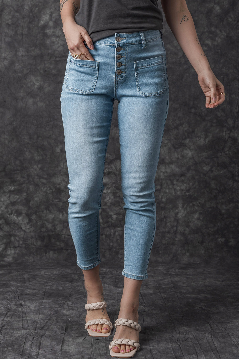 Dark blue skinny jeans featuring a button fly closure and pockets, designed for a stylish and comfortable fit.