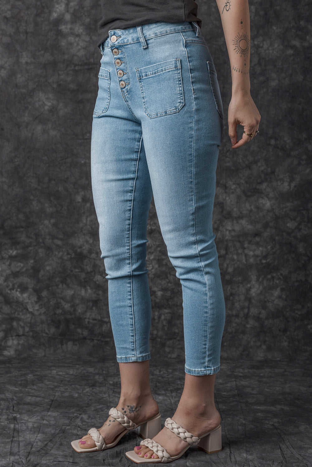 Dark blue skinny jeans featuring a button fly closure and pockets, designed for a stylish and comfortable fit.