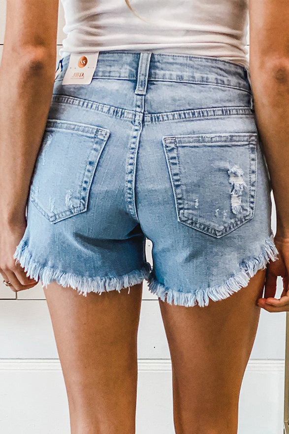 A pair of dark blue frayed hem denim shorts displayed on a white background, showcasing the stylish distressed design and pockets.