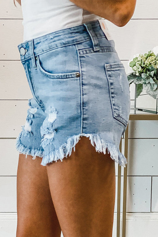 A pair of dark blue frayed hem denim shorts displayed on a white background, showcasing the stylish distressed design and pockets.