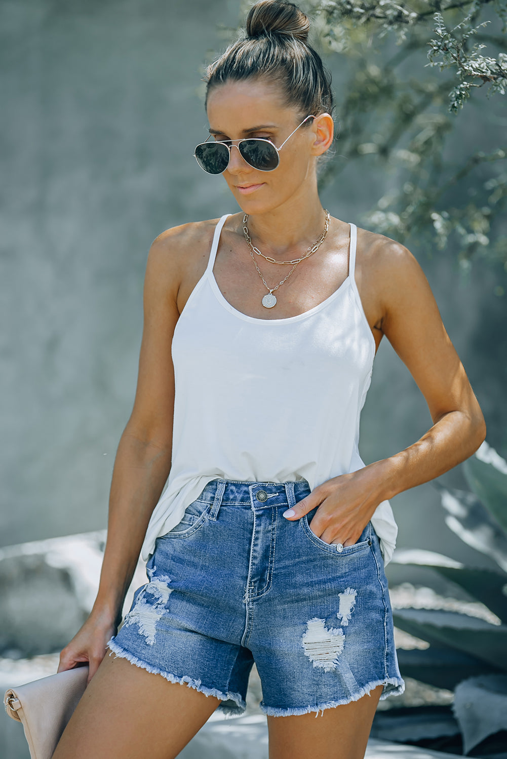 A pair of dark blue frayed hem denim shorts displayed on a white background, showcasing the stylish distressed design and pockets.