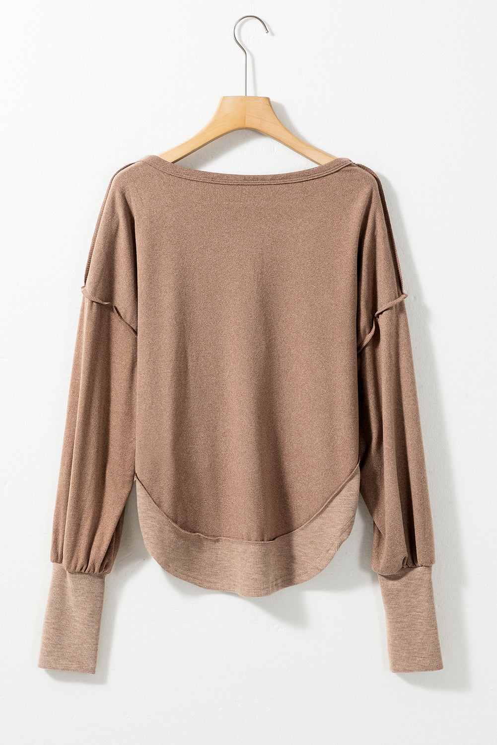 Dark brown sweatshirt featuring exposed seams, ribbed texture, thumbhole sleeves, and buttoned front, perfect for casual and active wear.