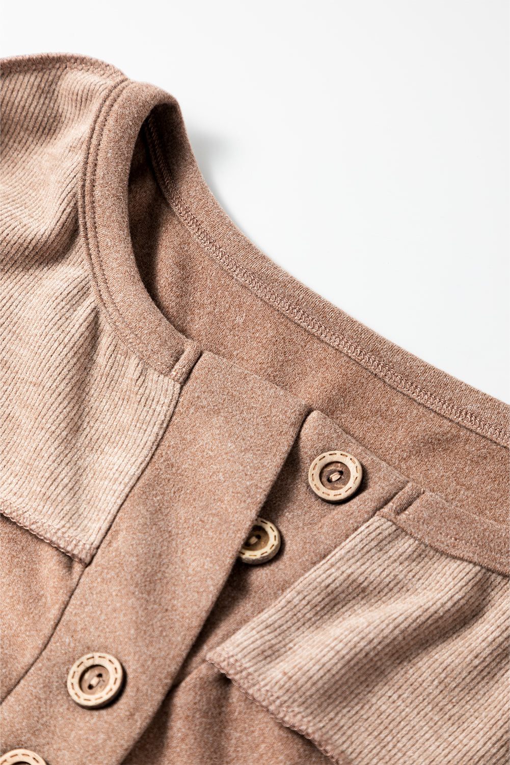 Dark brown sweatshirt featuring exposed seams, ribbed texture, thumbhole sleeves, and buttoned front, perfect for casual and active wear.