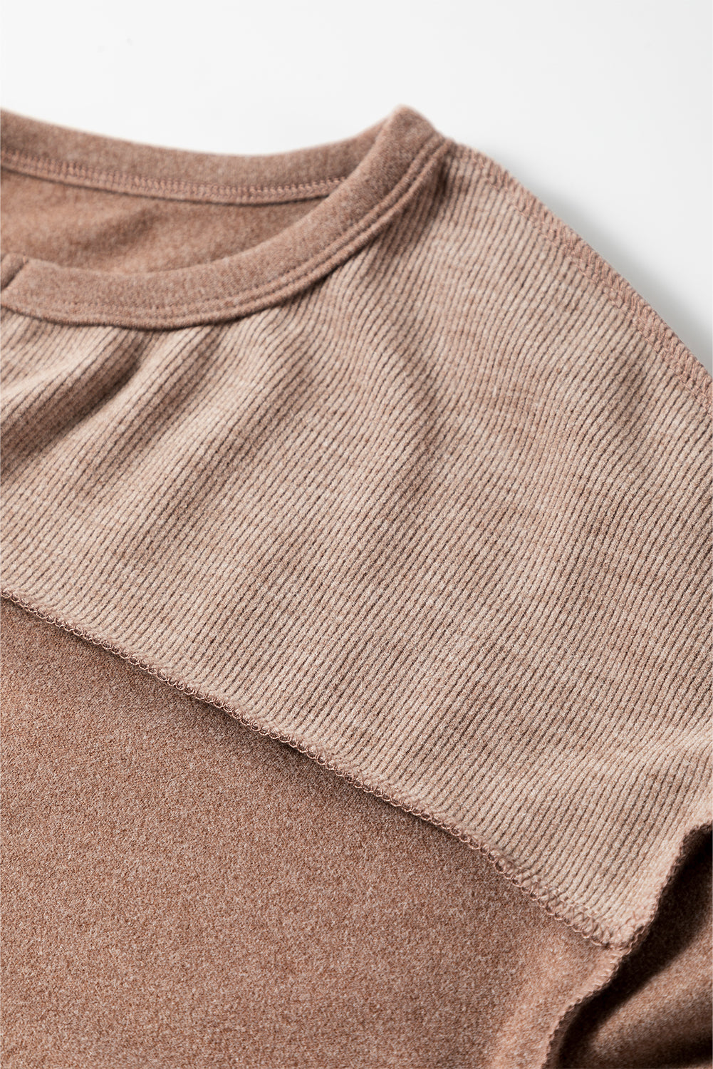 Dark brown sweatshirt featuring exposed seams, ribbed texture, thumbhole sleeves, and buttoned front, perfect for casual and active wear.