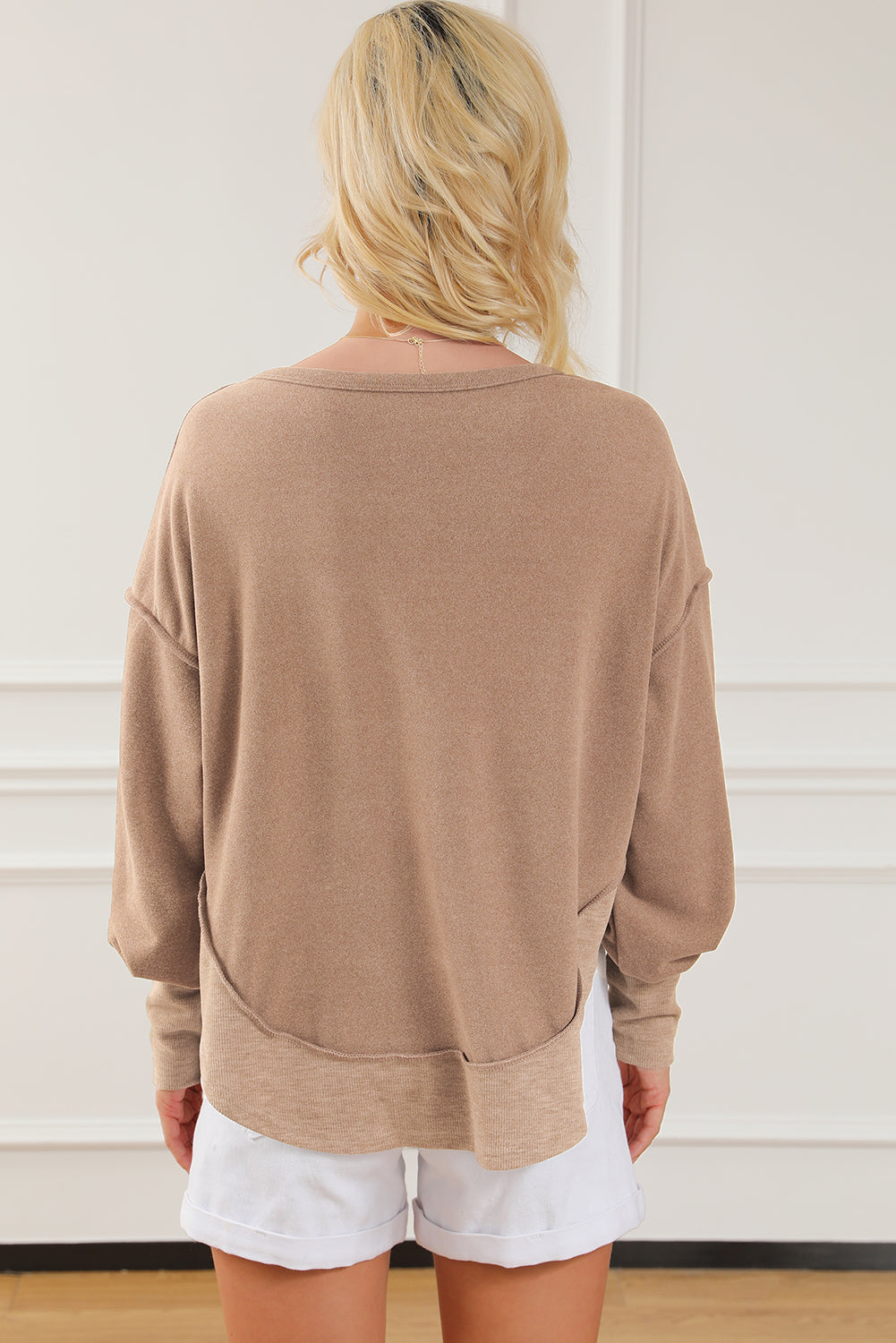 Dark brown sweatshirt featuring exposed seams, ribbed texture, thumbhole sleeves, and buttoned front, perfect for casual and active wear.