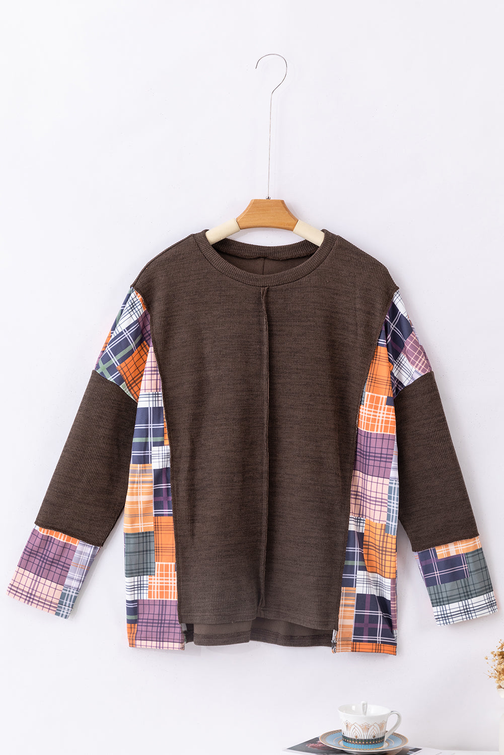 Dark brown plaid patchwork knit top with exposed seams and a high-low hem, showcasing a stylish and relaxed fit.