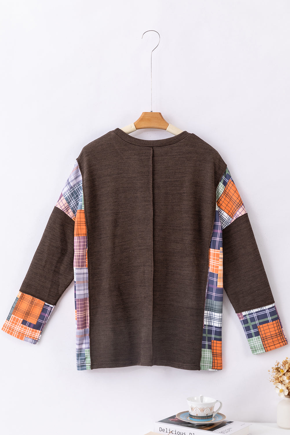 Dark brown plaid patchwork knit top with exposed seams and a high-low hem, showcasing a stylish and relaxed fit.