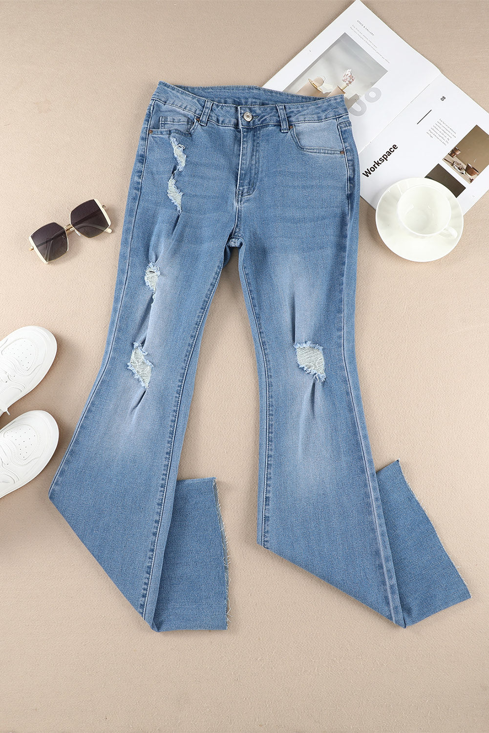 A pair of dark wash mid rise flare jeans featuring a trendy ripped design and raw hem detail, perfect for stylish casual wear.