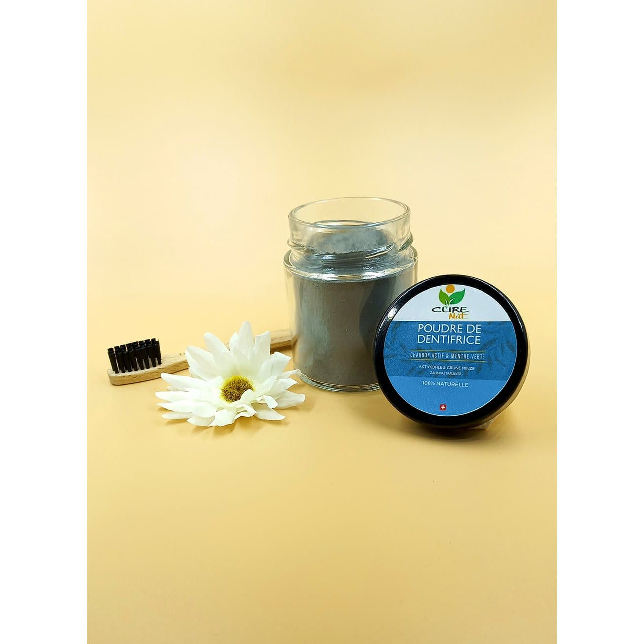 A jar of Dentifrice Blanchissant Menthe Verte et Charbon Actif featuring natural ingredients like activated charcoal and green mint.