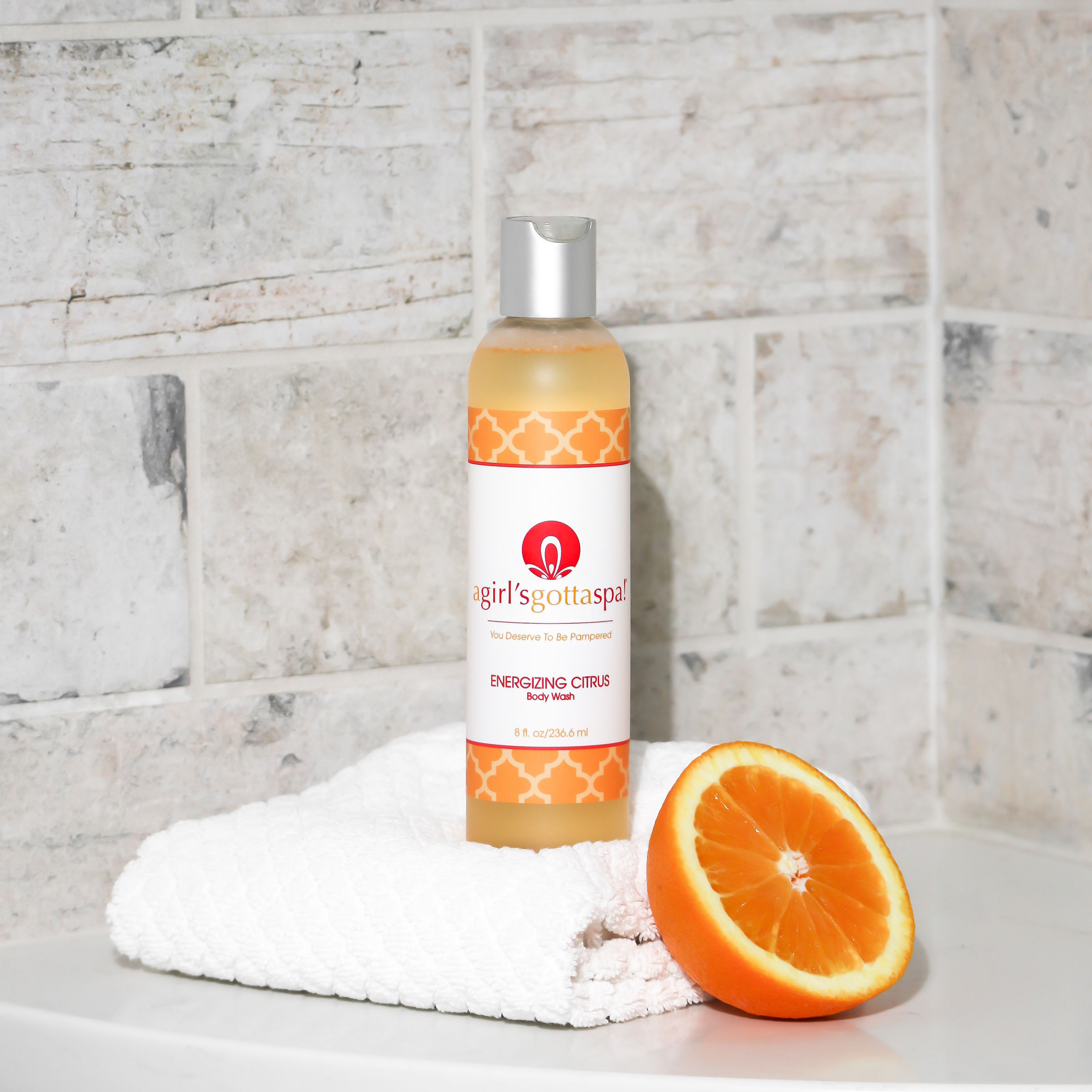 A bottle of A Girl's Gotta Spa! Energizing Citrus Body Wash featuring a vibrant citrus design, showcasing its refreshing and hydrating properties.