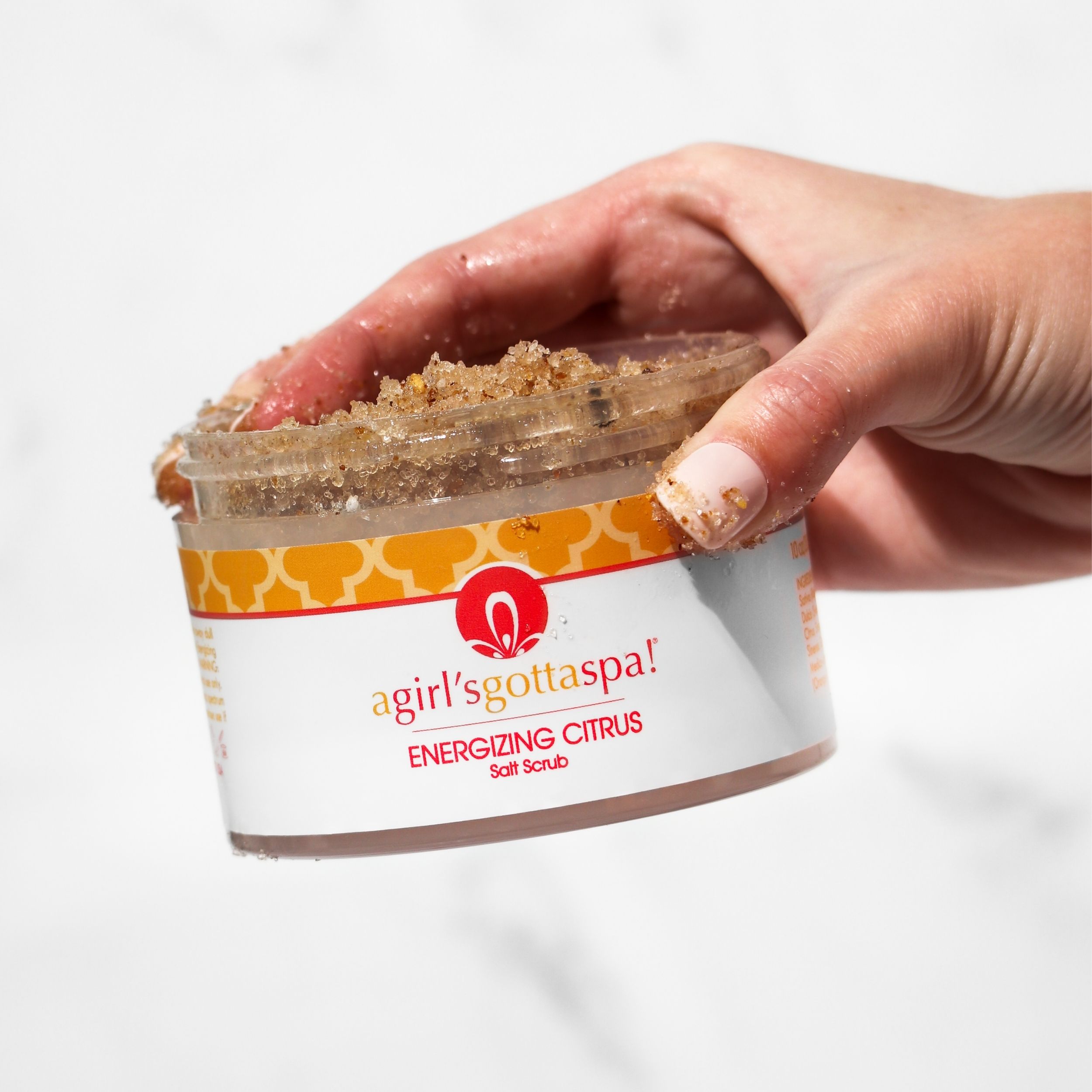 Energizing Citrus Salt Body Scrub in a jar with a wooden spoon, showcasing its vibrant texture and citrus scent.