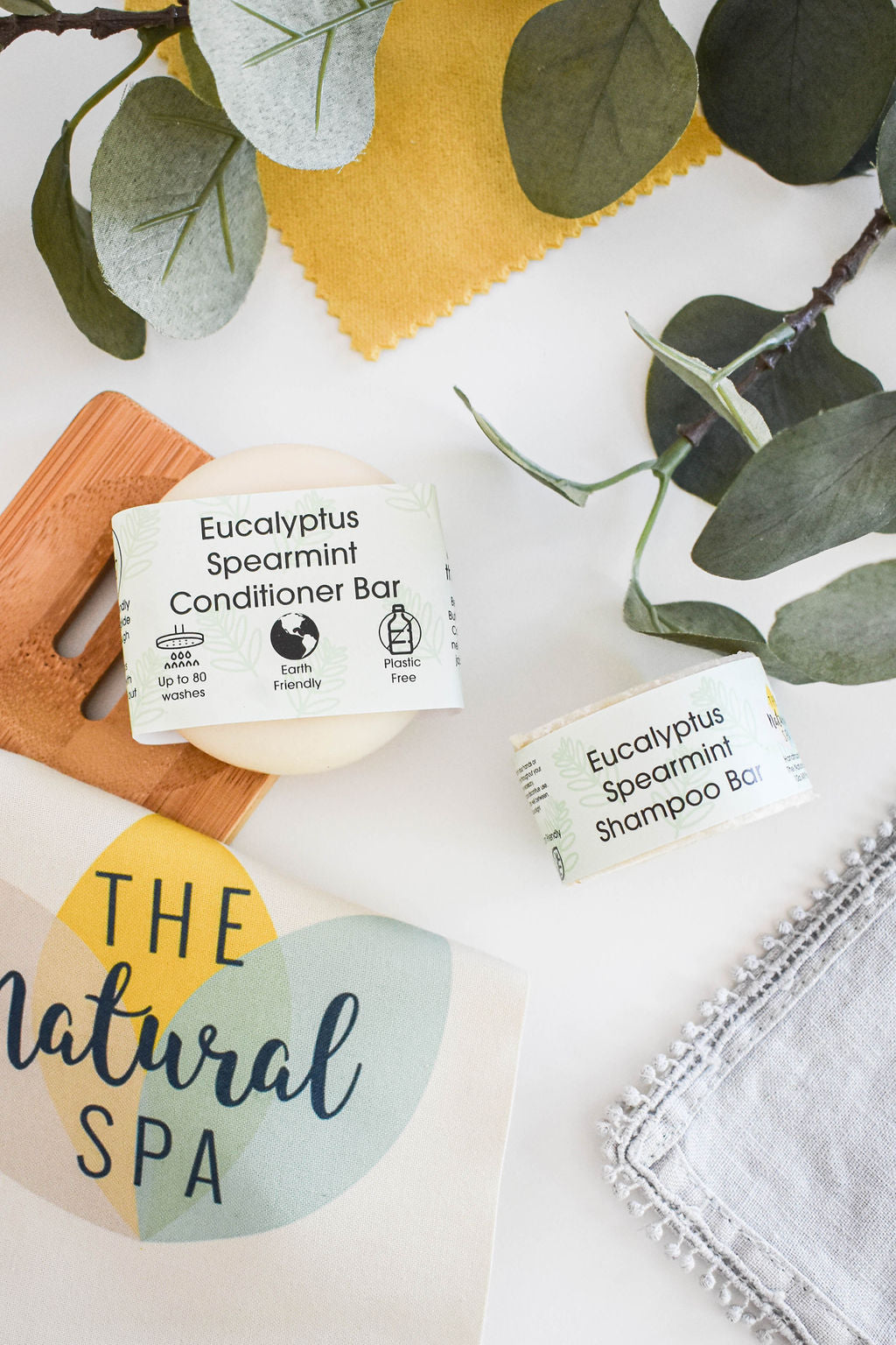 Eucalyptus Spearmint Shampoo and Conditioner Bar set displayed on a wooden surface, showcasing the eco-friendly packaging and vibrant colors of the bars.