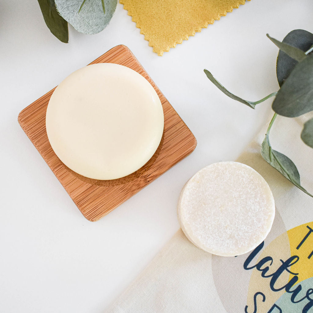 Eucalyptus Spearmint Shampoo and Conditioner Bar set displayed on a wooden surface, showcasing the eco-friendly packaging and vibrant colors of the bars.